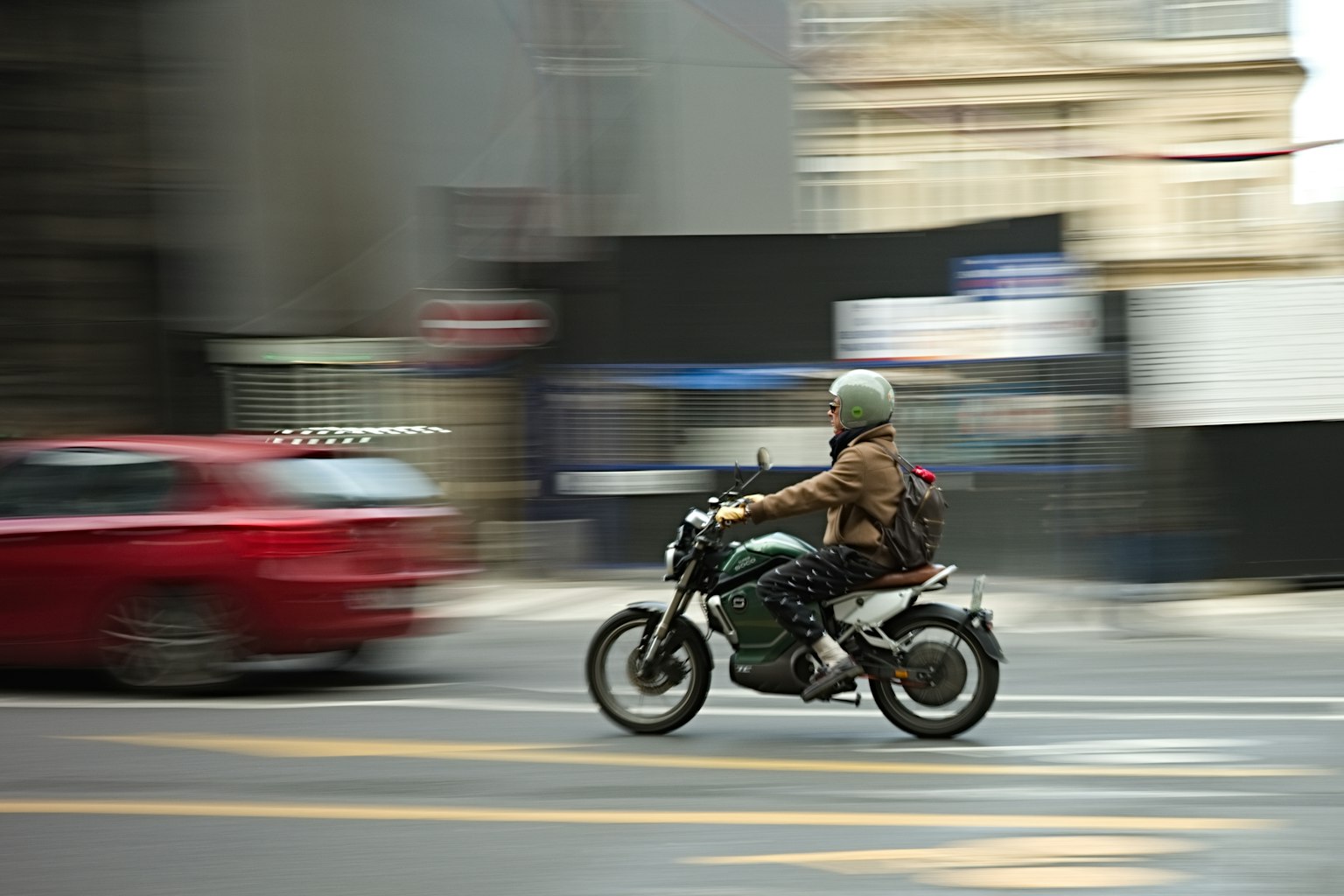 一名男子快速騎著摩托車穿過城市
