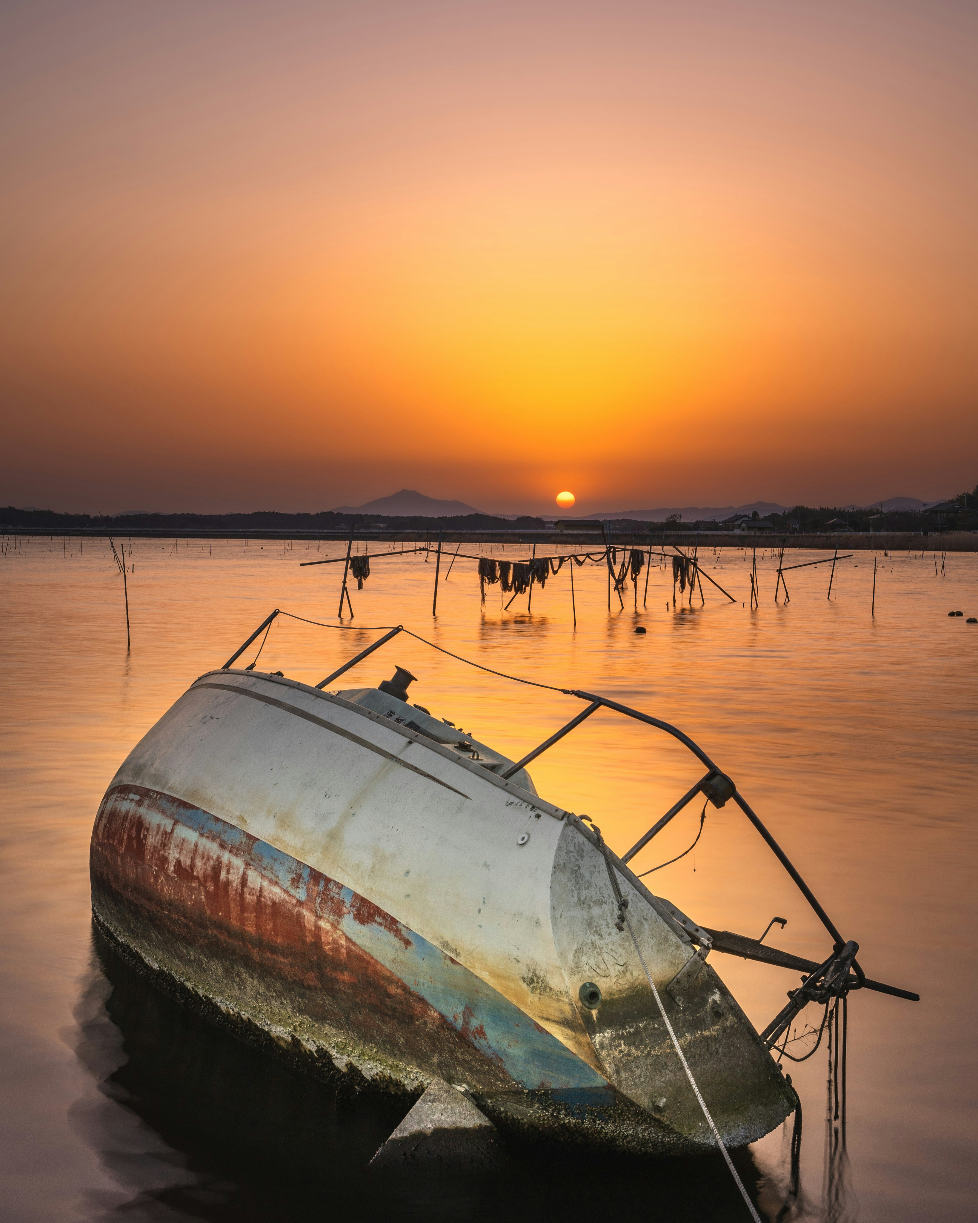 夕阳下海边漂浮的旧船