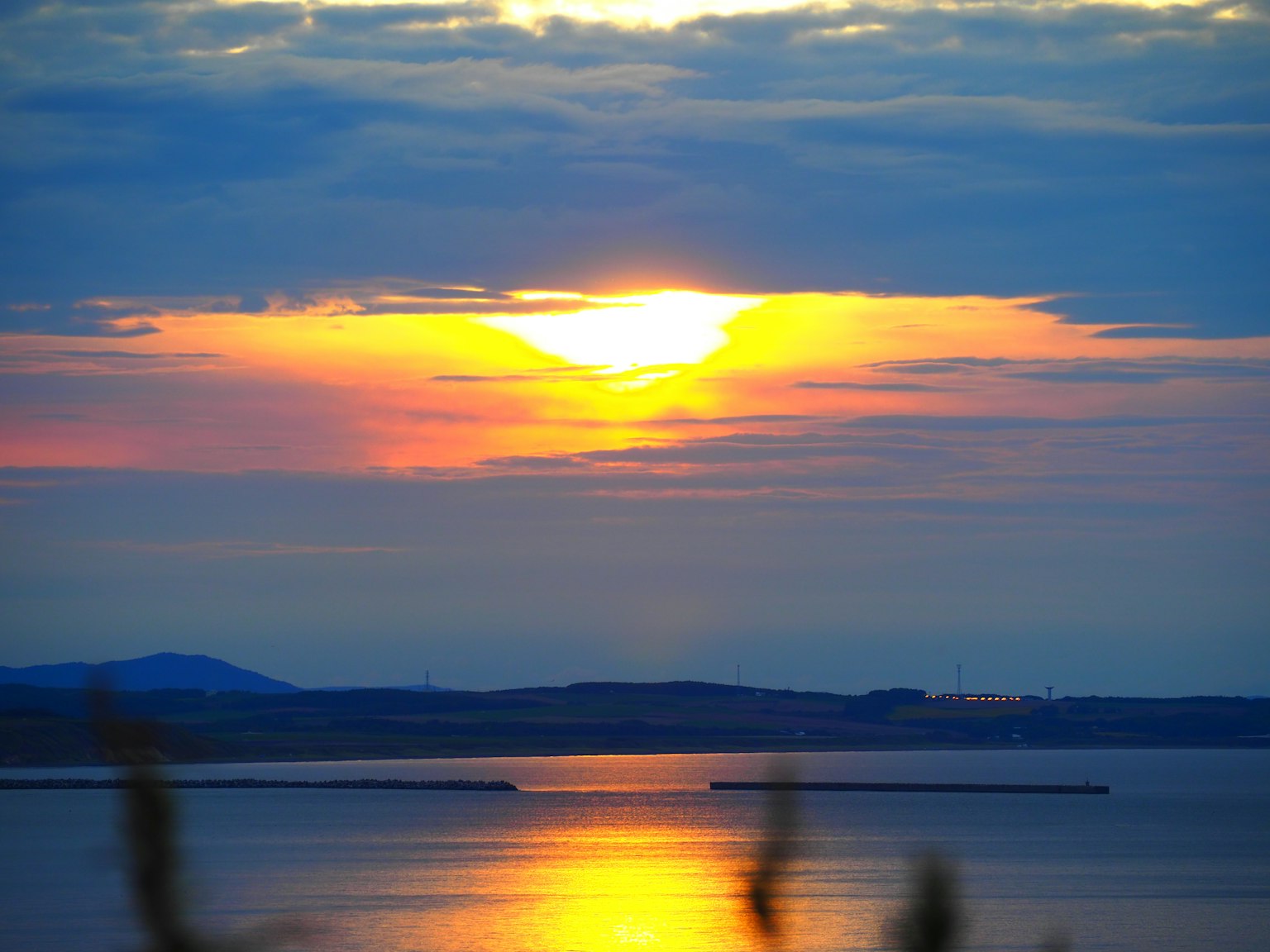 Coucher de soleil sur un lac avec des couleurs vives et des nuages