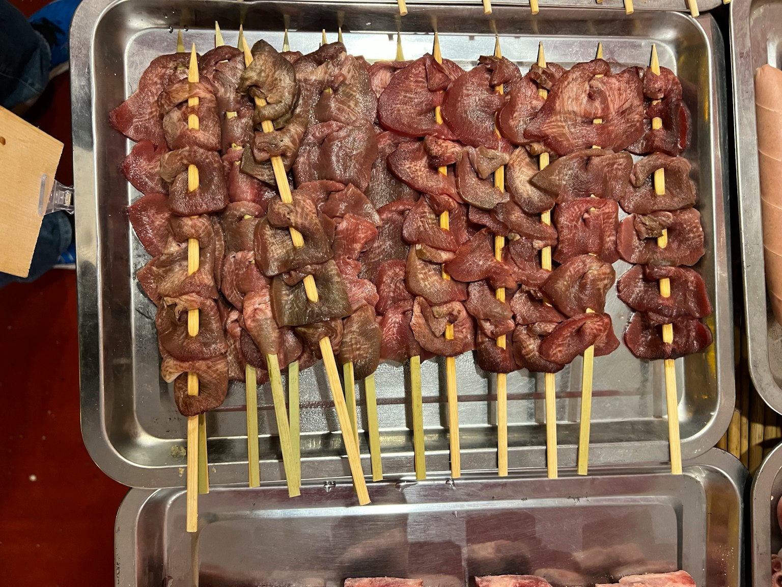 Spiedini di carne marinata disposti su un vassoio