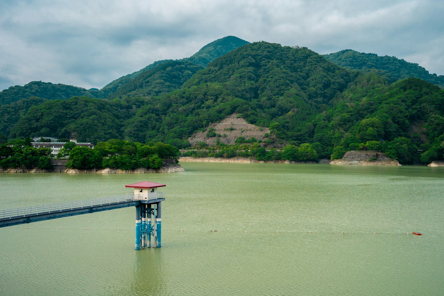 ทิวทัศน์ที่สวยงามของท่าเรือพร้อมหอคอยสีสันสดใสที่มองออกไปยังน้ำสีเขียวและภูเขา
