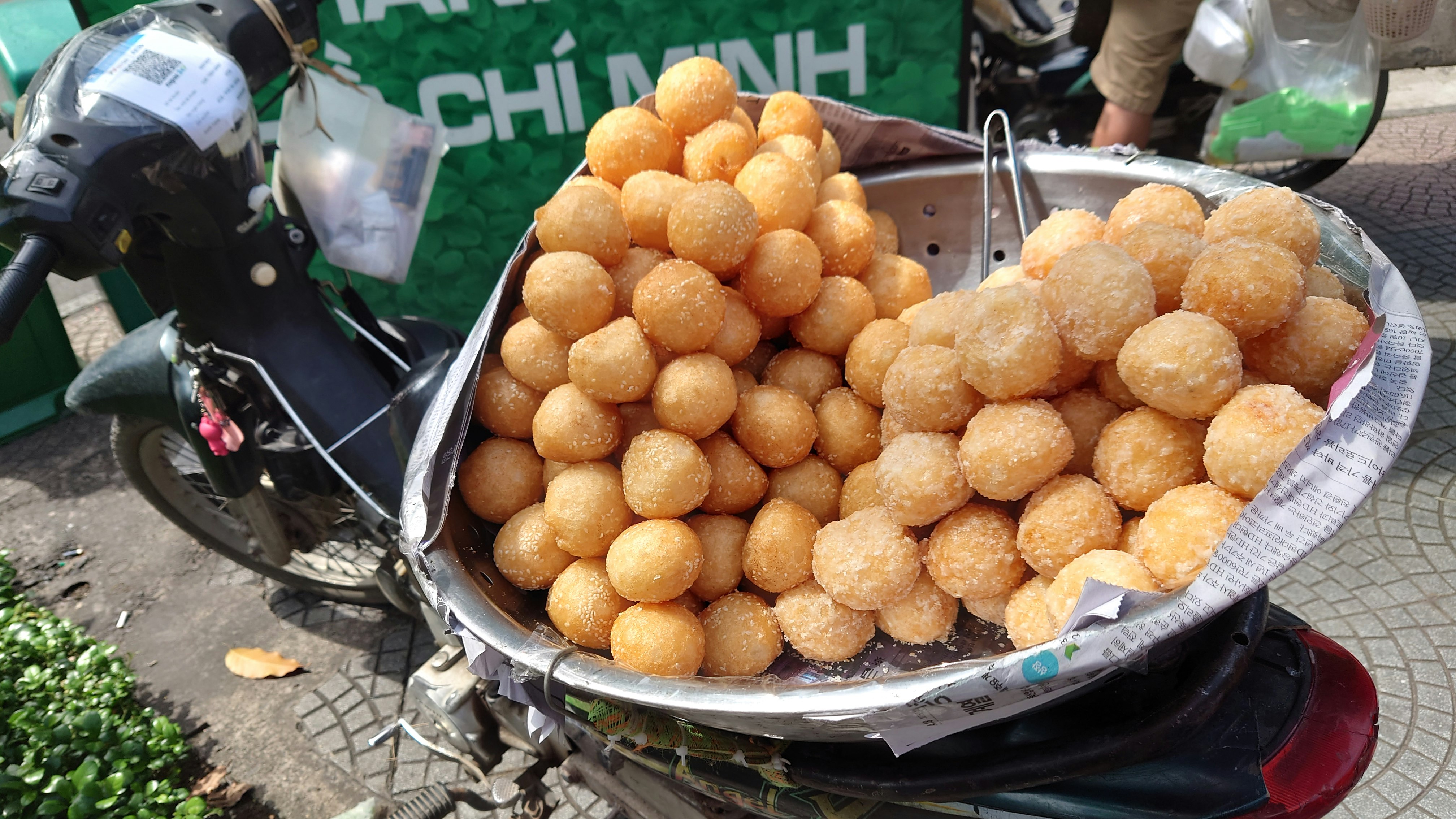 Street vendor cart piled with fried dough balls