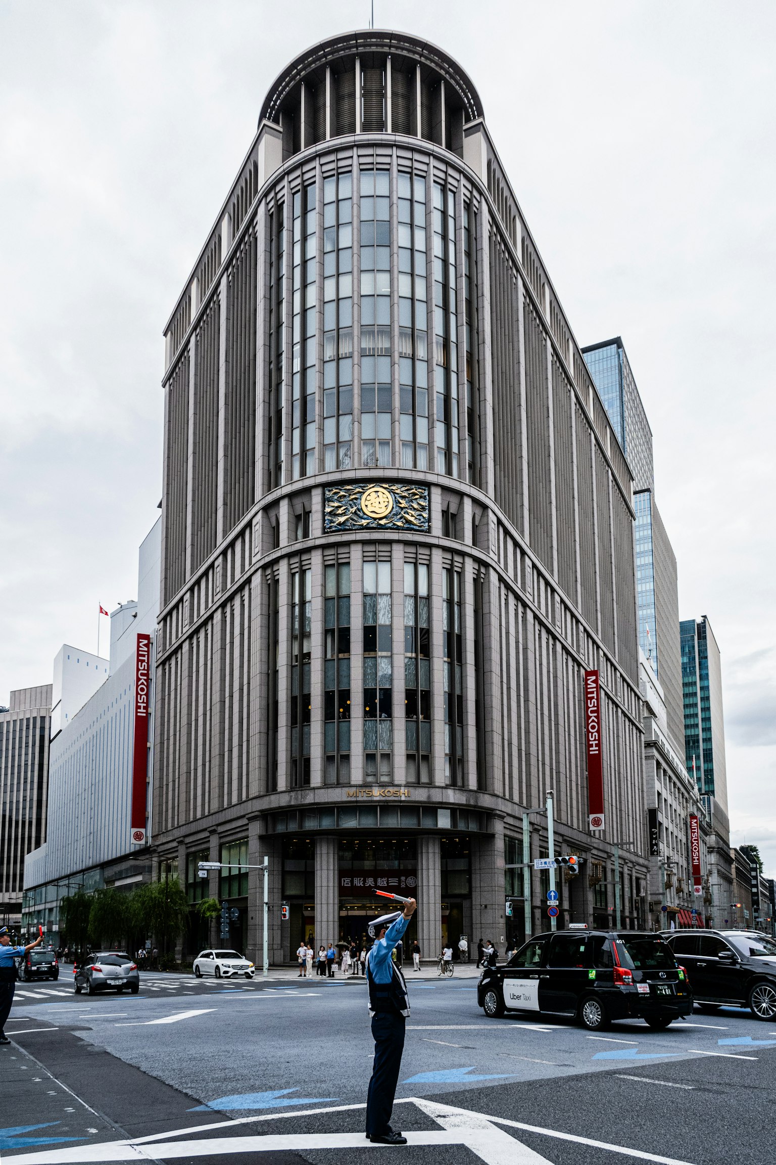 一个大型建筑在十字路口，有警察指挥交通