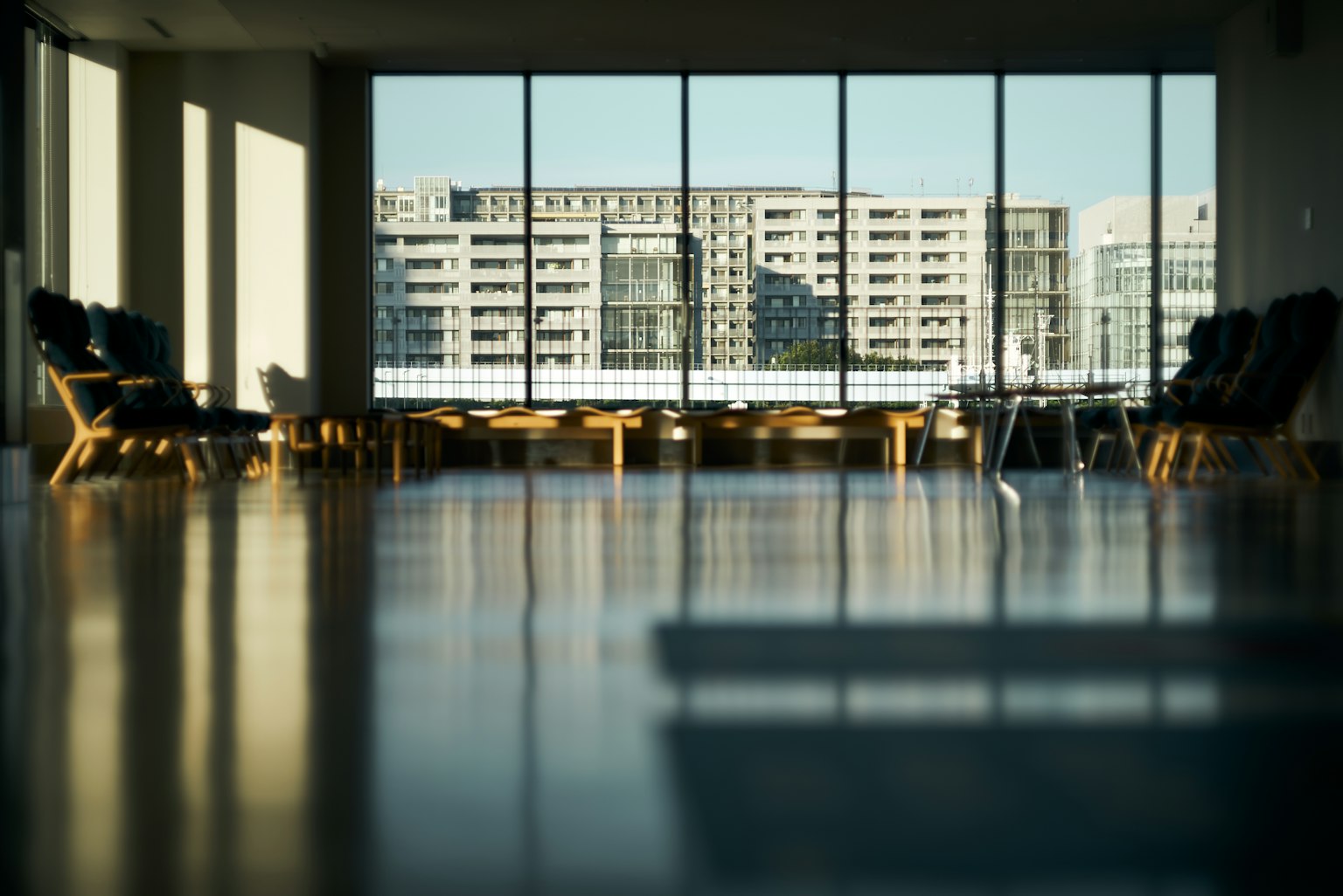 Espacio interior brillante con grandes ventanas que muestran una vista de la ciudad