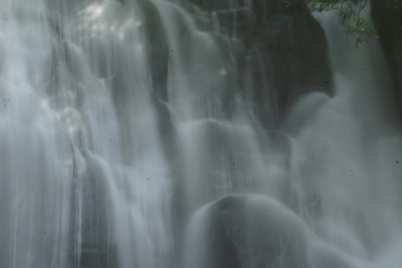 Air terjun mengalir anggun dengan cahaya lembut yang menciptakan efek berkilau