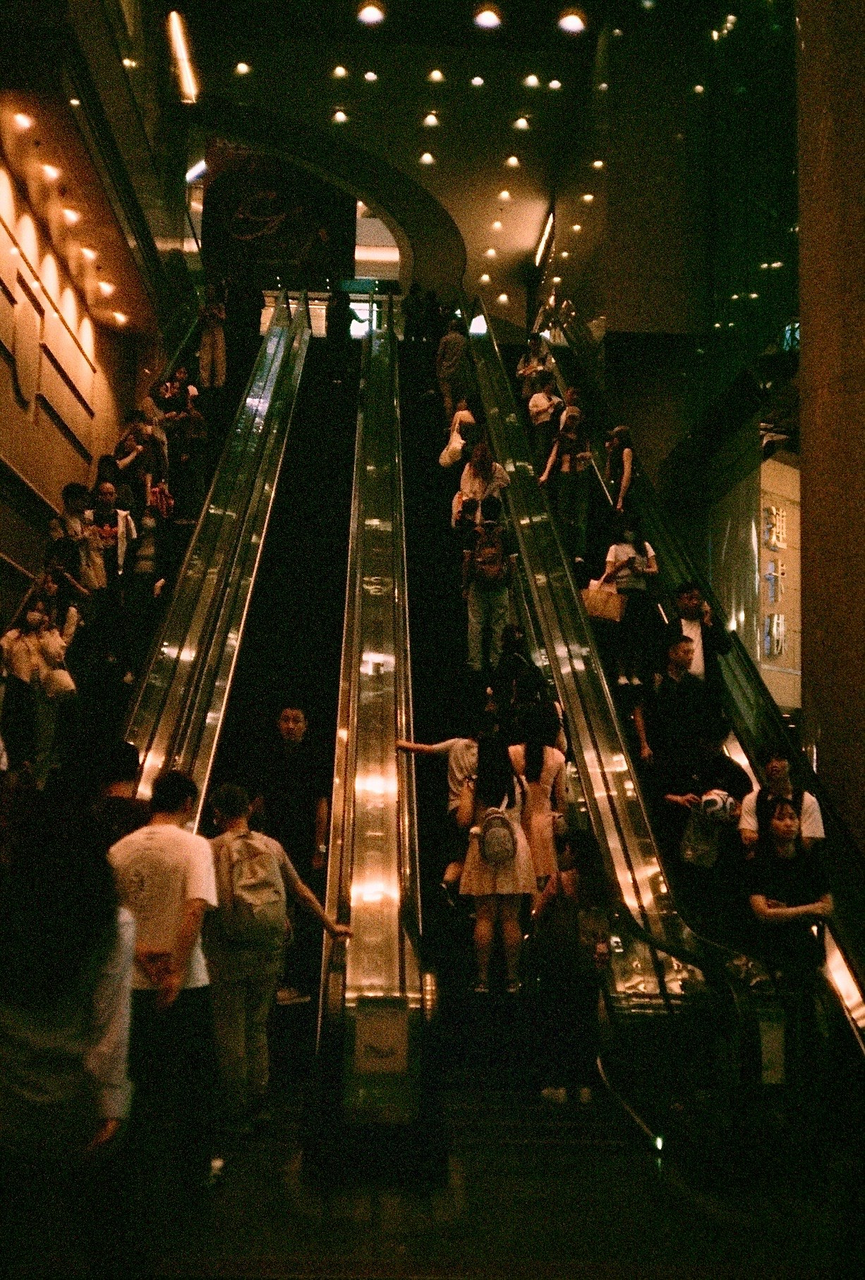 People on an indoor staircase at night with glowing lights