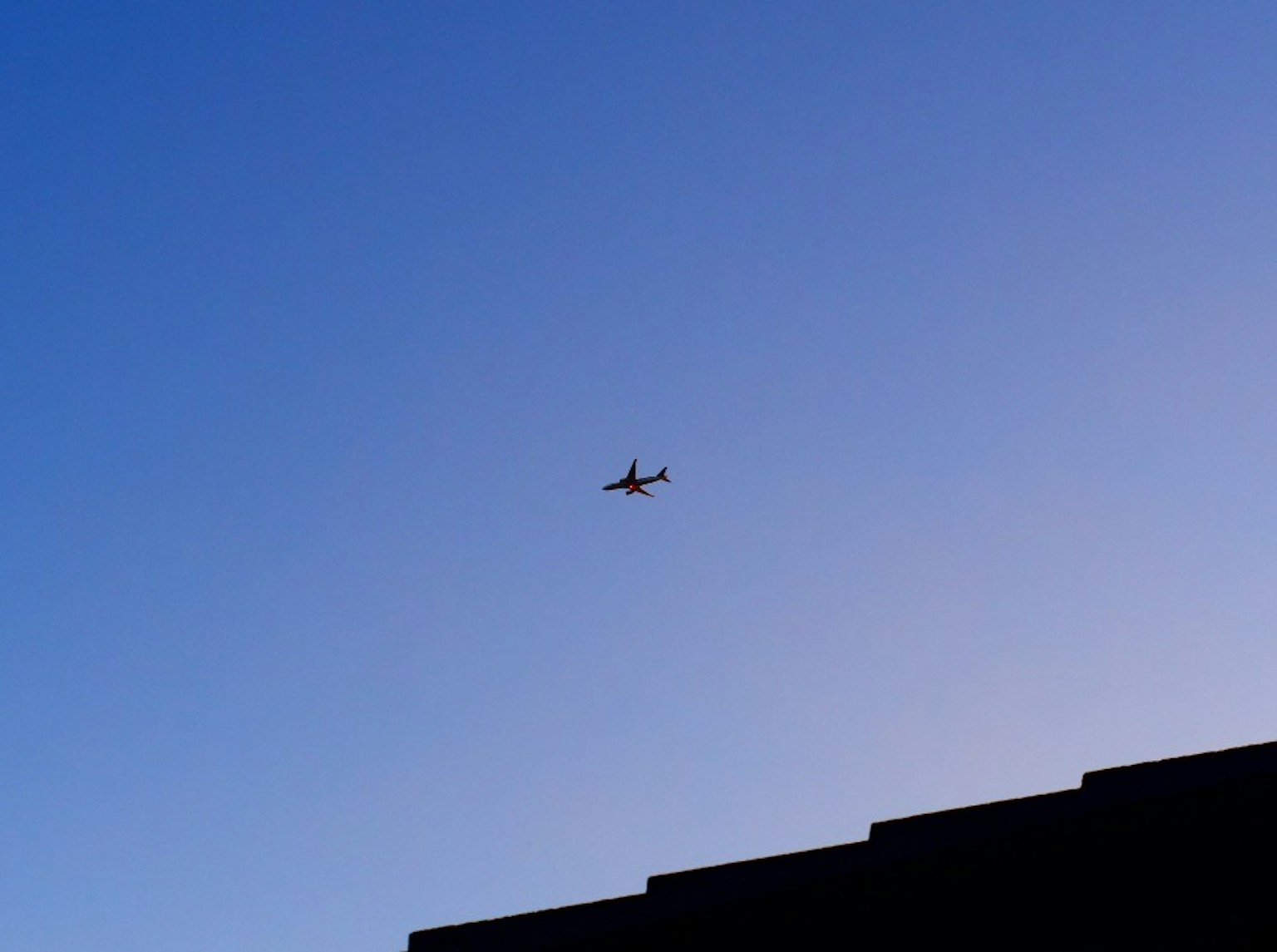 Silhouette de un avión contra un cielo azul