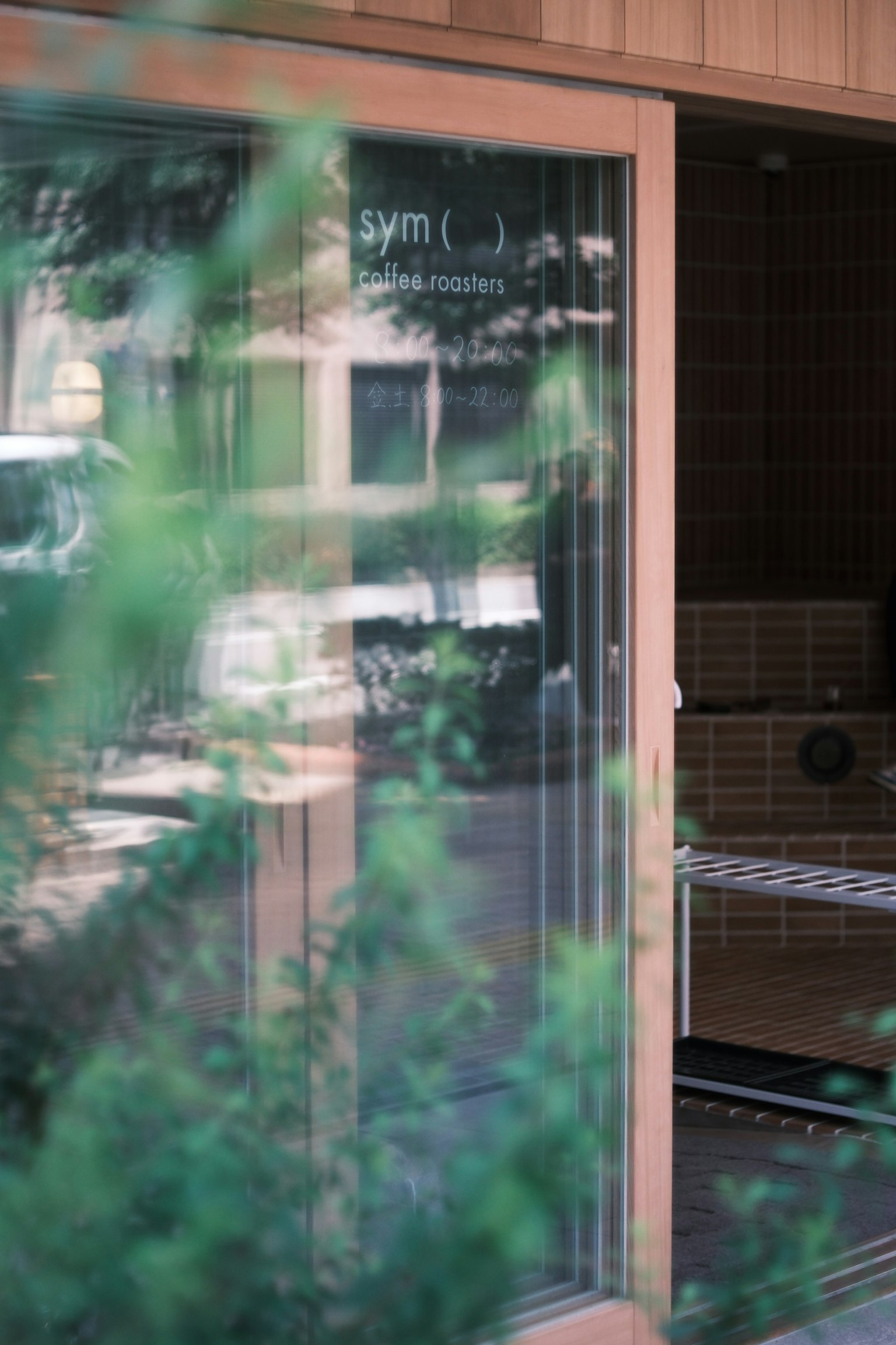 Porte en verre révélant l'intérieur d'une salle de sport avec de la verdure