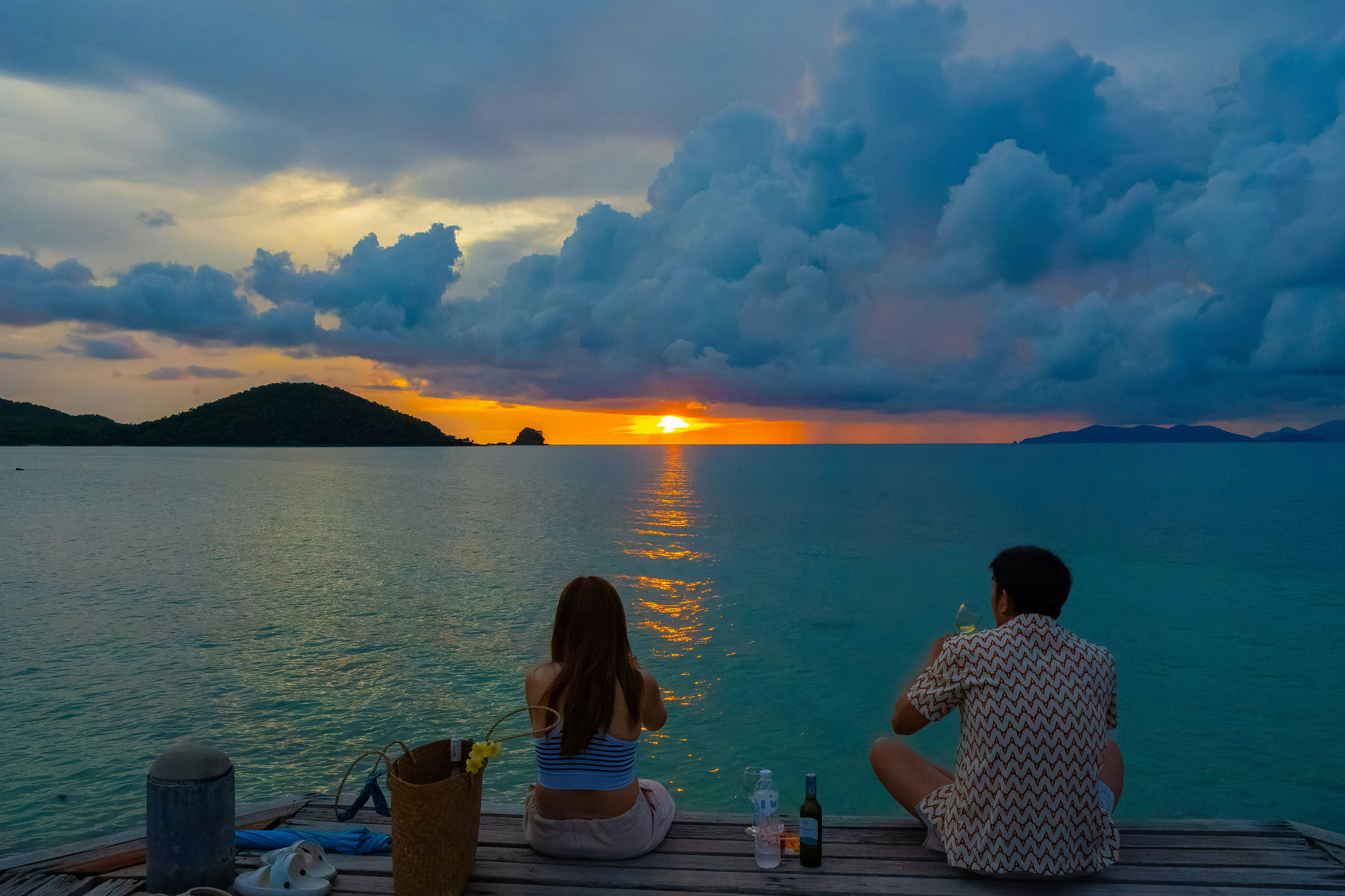 見晴らしのよい海辺の夕景で寄り添う2人