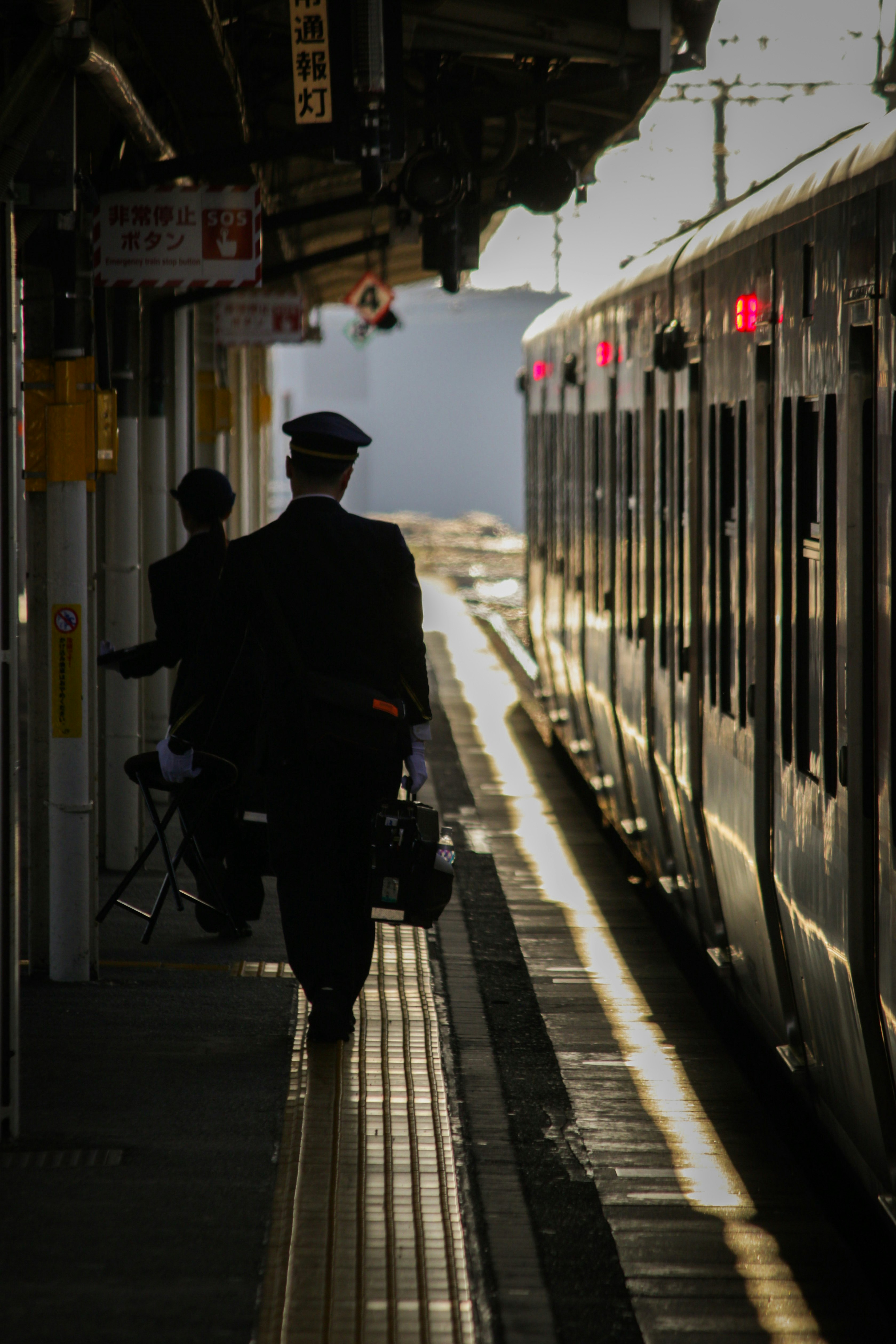 路地の奥へ続く駅構内のホームで人が歩く風景