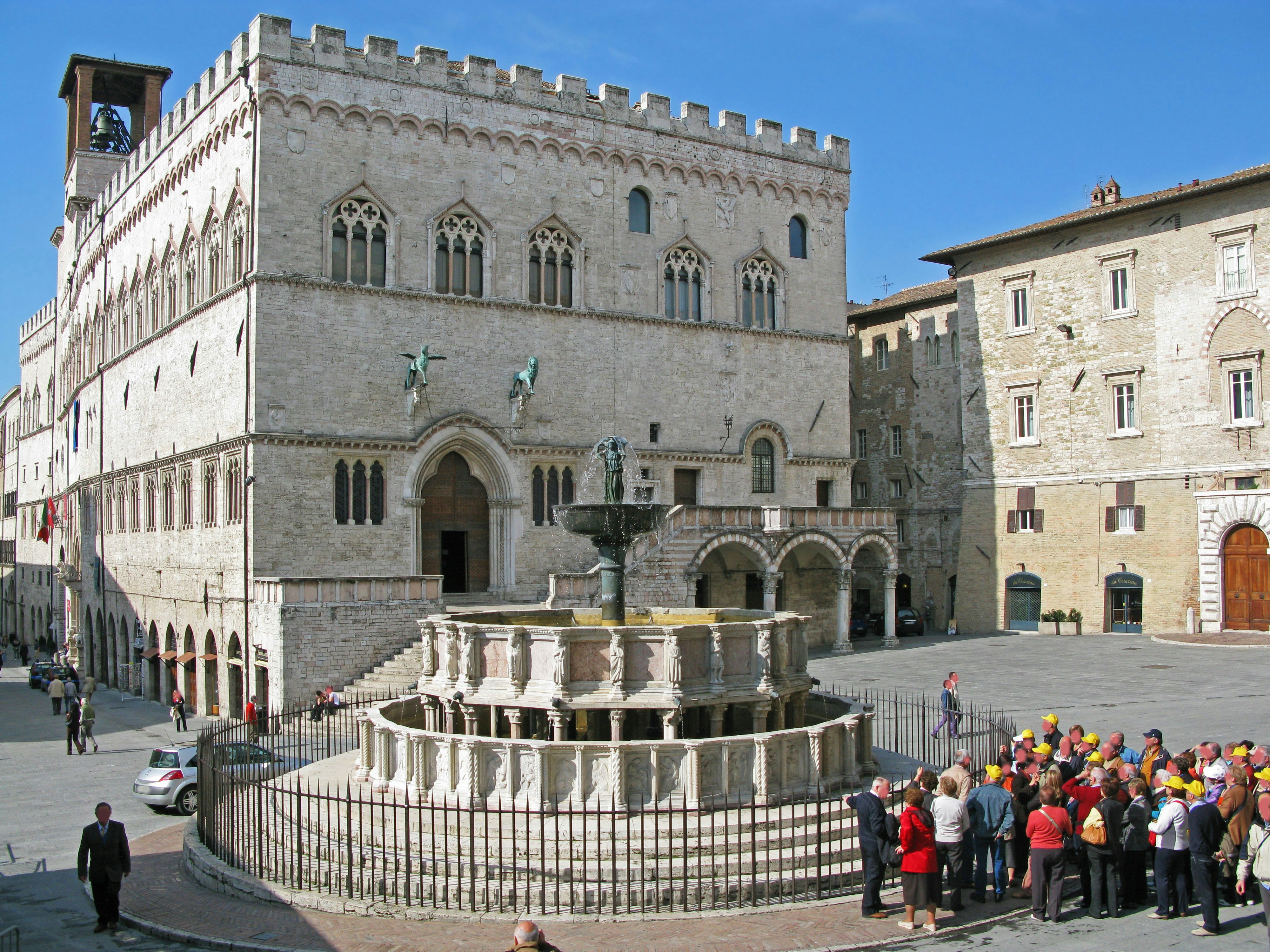 historische Steinbauten und ein Brunnen auf einem Platz