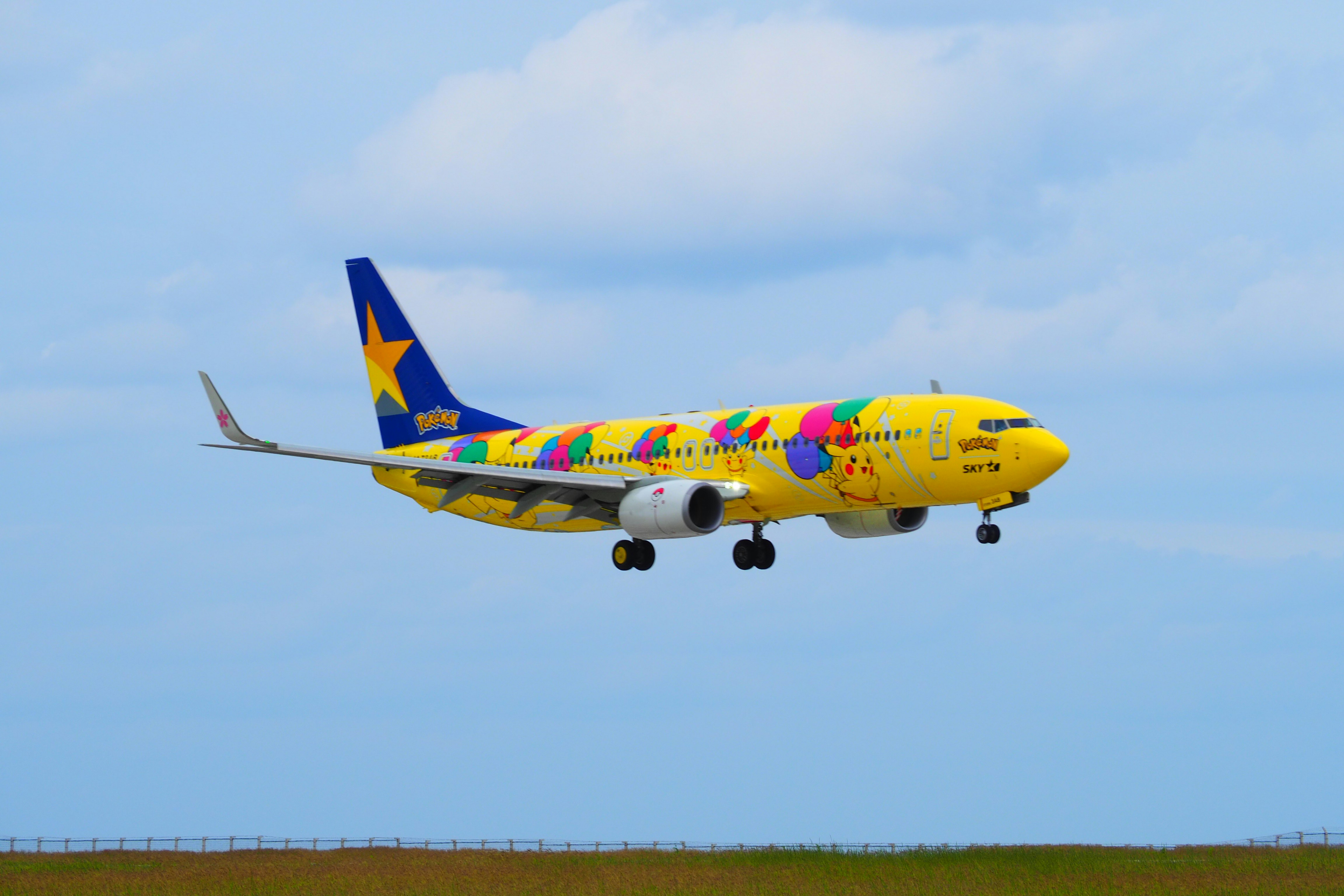 青空を飛ぶカラフルな旅客機の離陸シーン