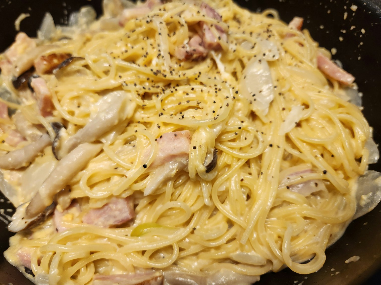 奶油意大利面上放有鸡肉和黑胡椒