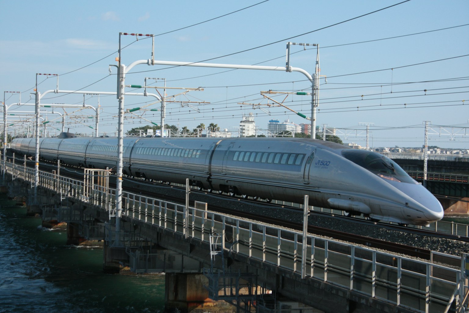 Kereta Shinkansen perak melintasi jembatan