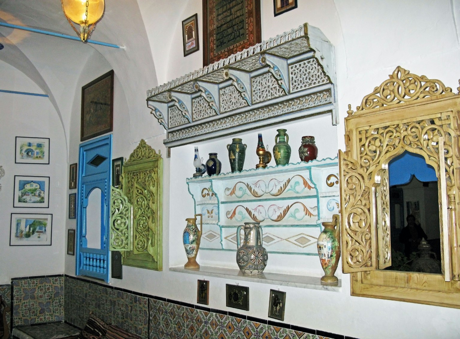 Interno con una parete decorata con ceramiche colorate e specchi