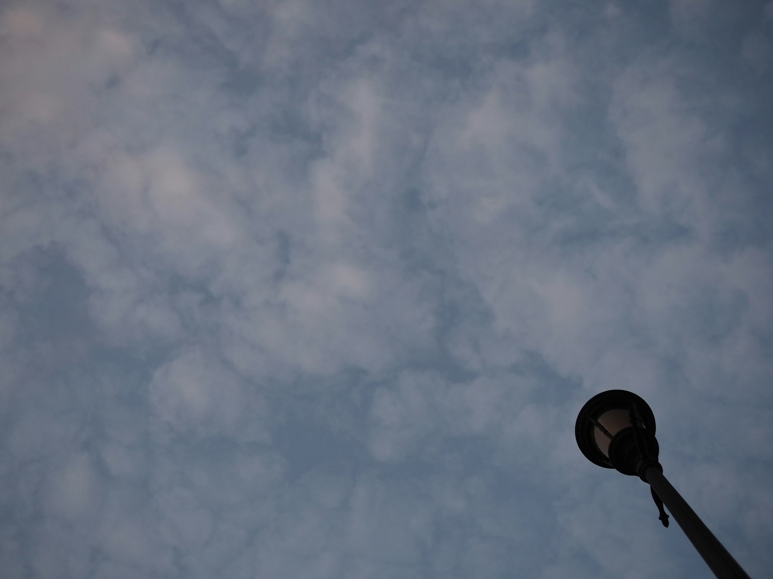 Lámpara de calle contra un fondo de cielo azul y nubes tenues