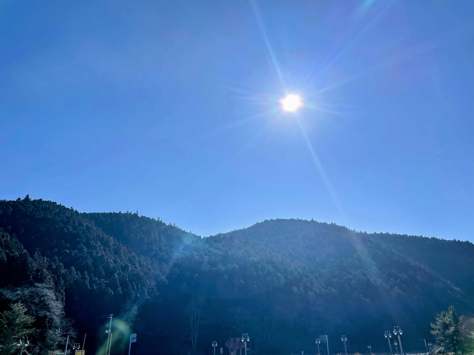 Soleil brillant sur des montagnes vertes sous un ciel bleu dégagé
