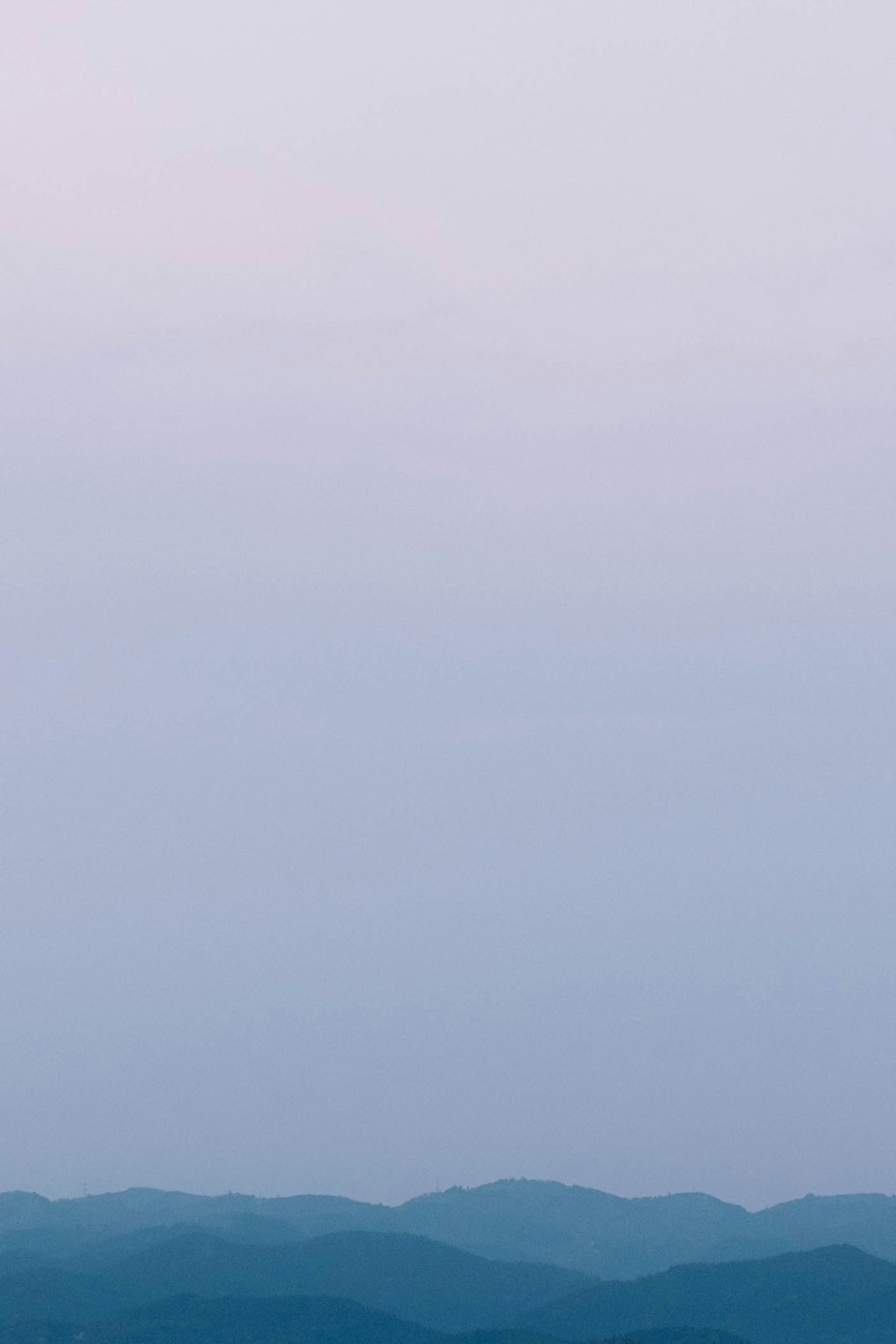 Douces montagnes bleues avec un dégradé de ciel pâle
