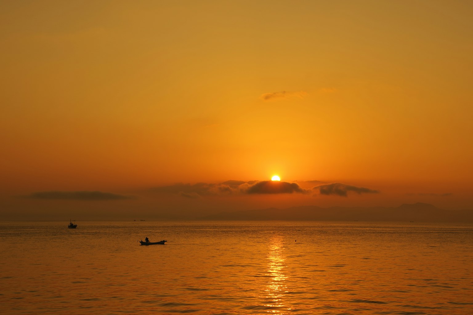 Atardecer naranja sobre el mar con una superficie de agua tranquila