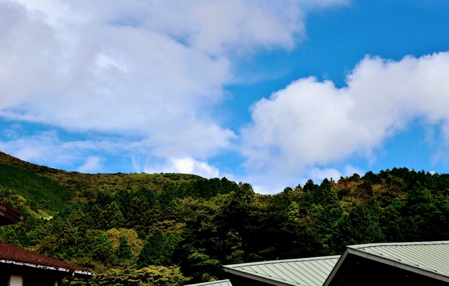 Scenic view of mountains with blue sky and fluffy white clouds