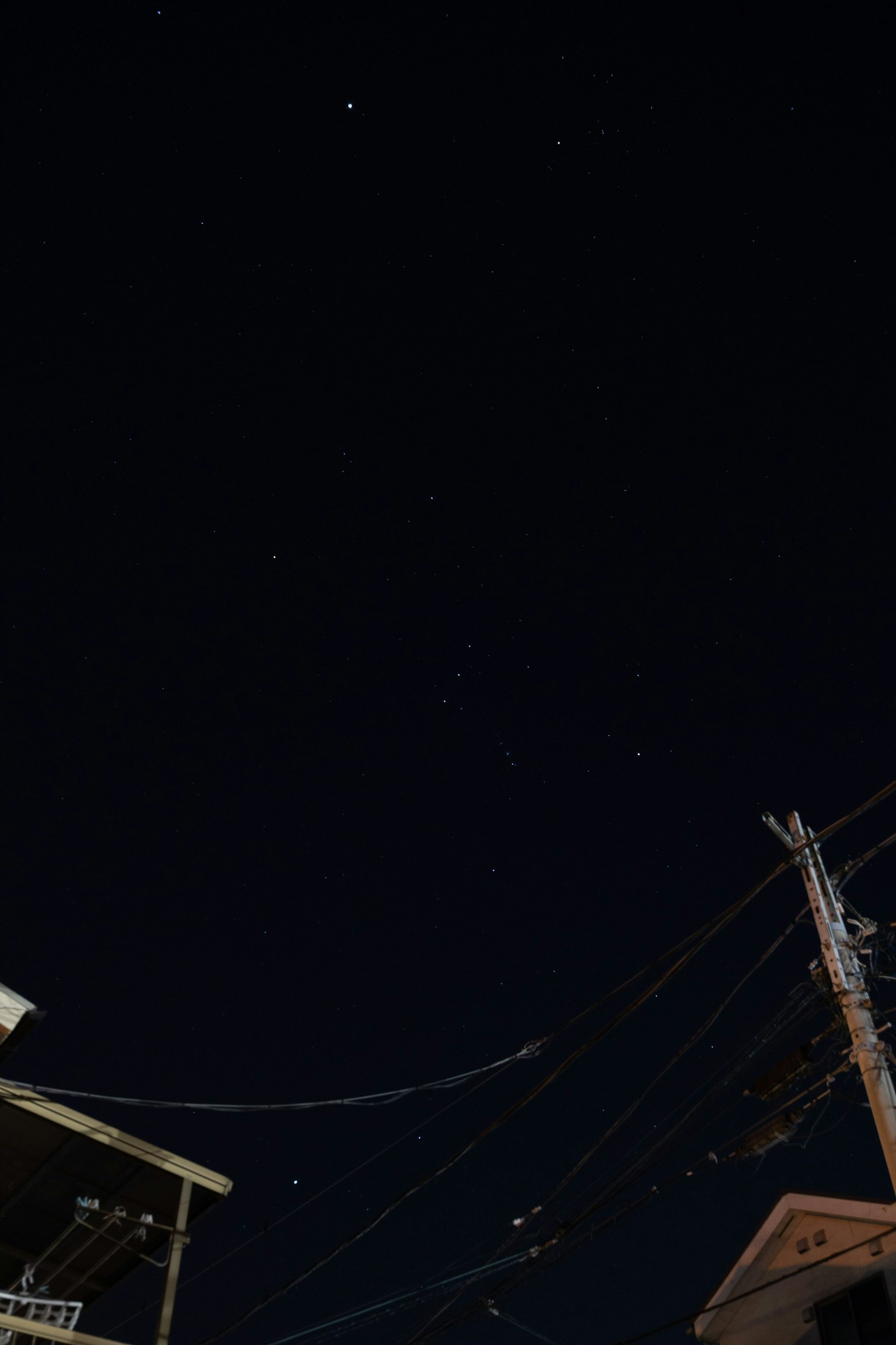 夜空に星が輝く風景と電線のある街の一角