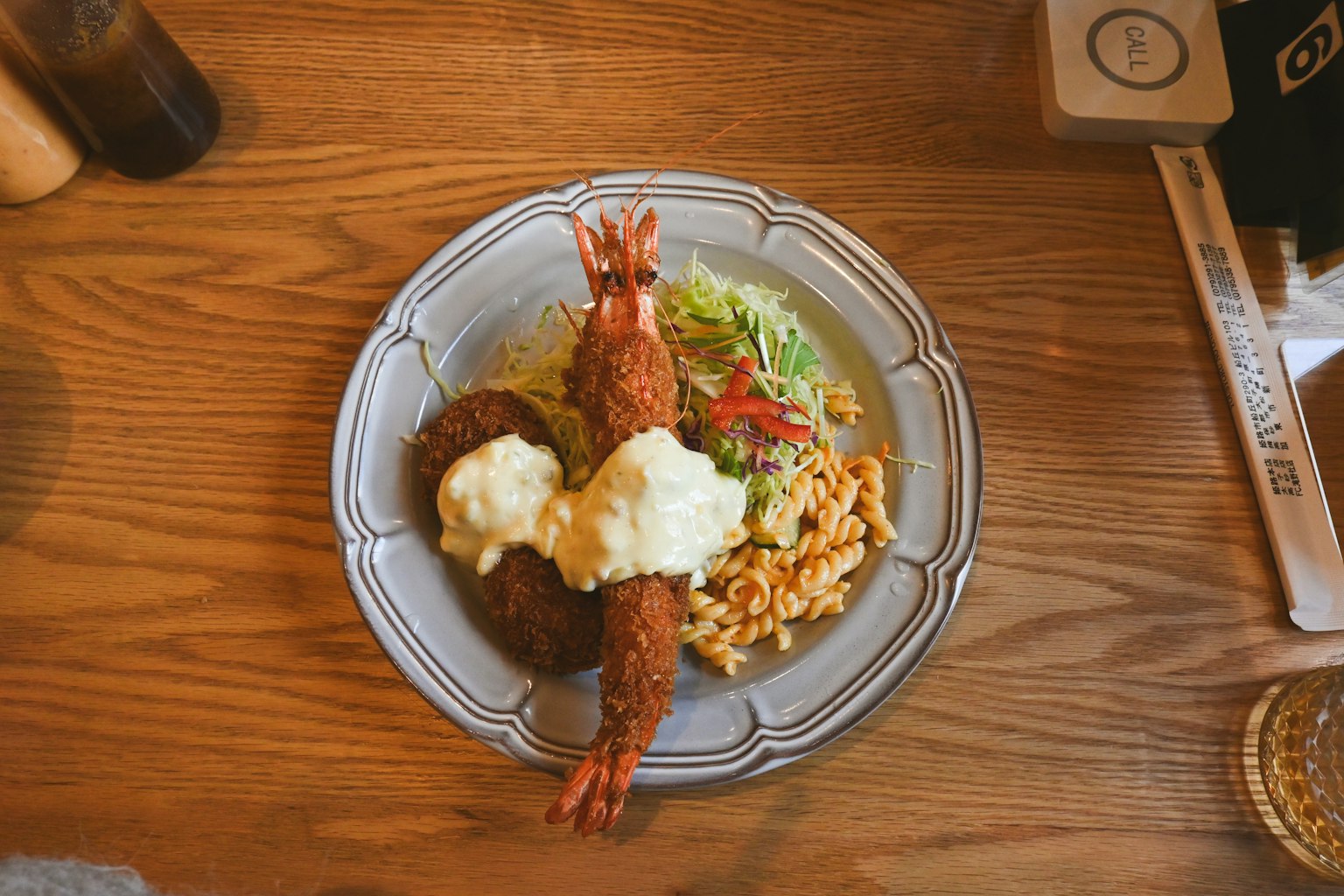 Ein Teller mit gebratenen Garnelen und Kroketten, serviert mit Salat und Reis