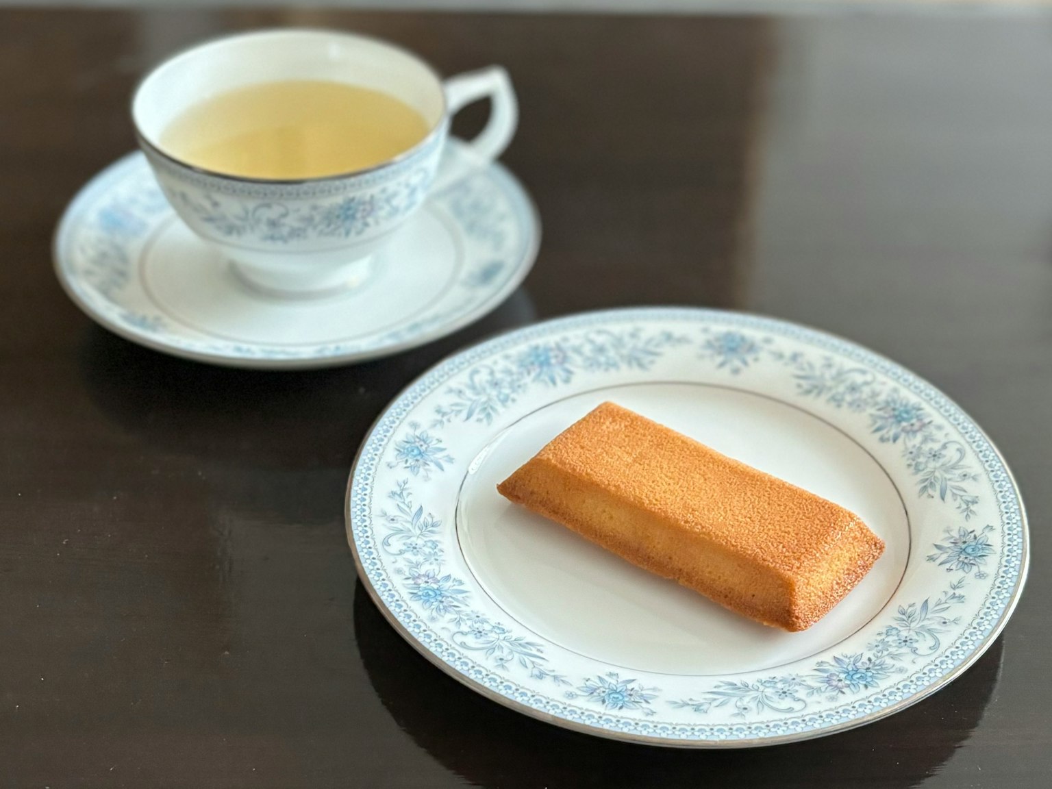 一杯茶和一个装饰盘上的长方形糕点