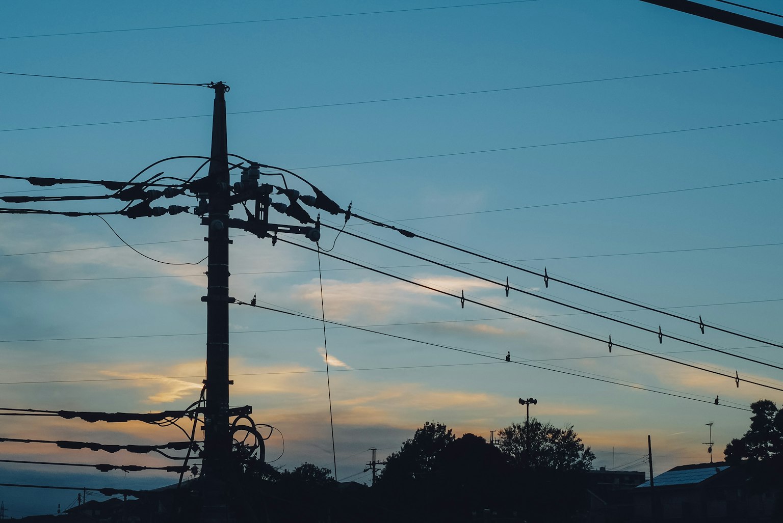 夕陽下電杆和電線的剪影