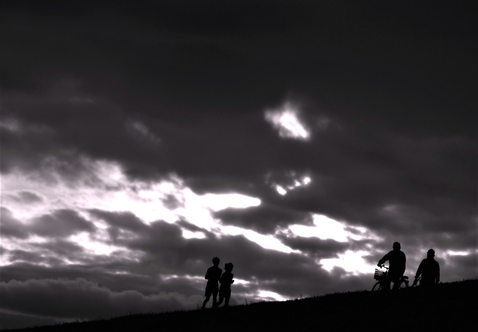 Silhouettes de personnes contre un ciel sombre