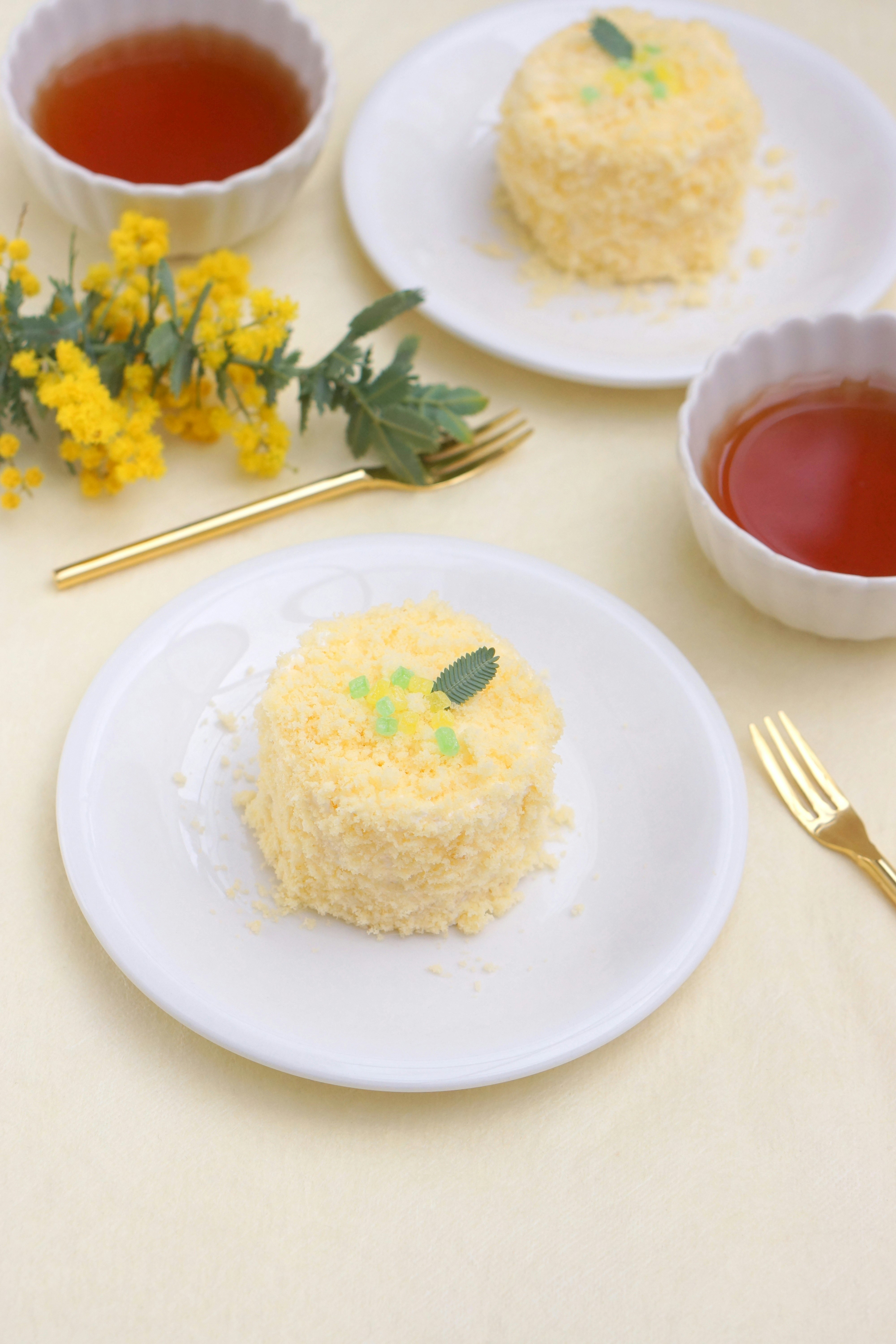 花とハーブを添えた白い皿のスイーツと紅茶