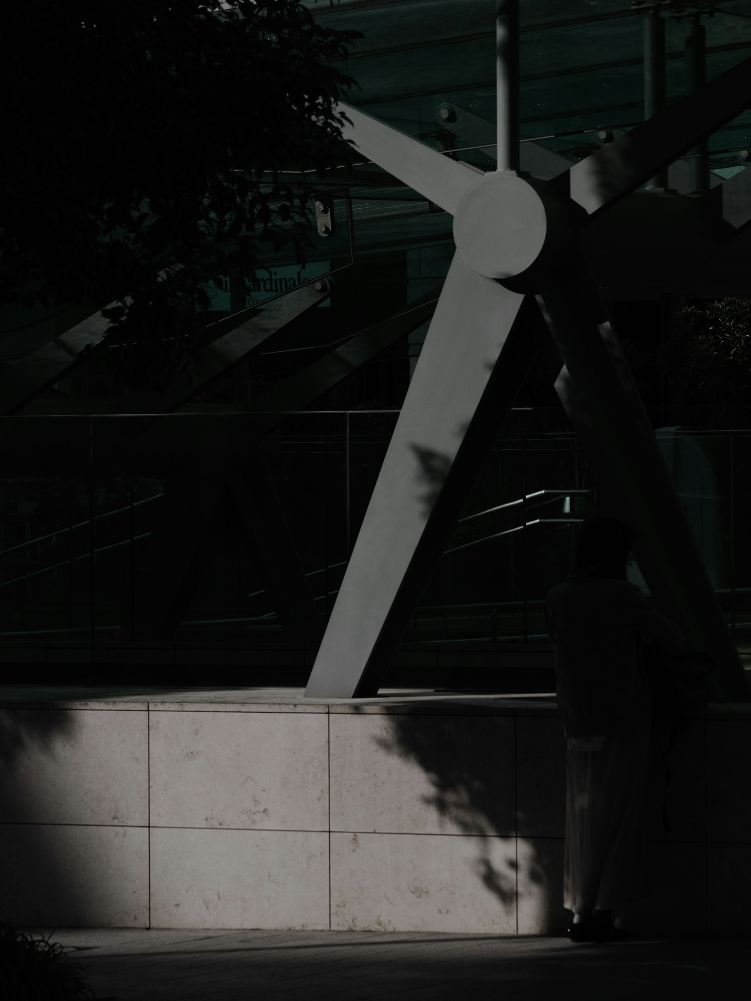 Escultura abstracta blanca en fondo oscuro con sombras