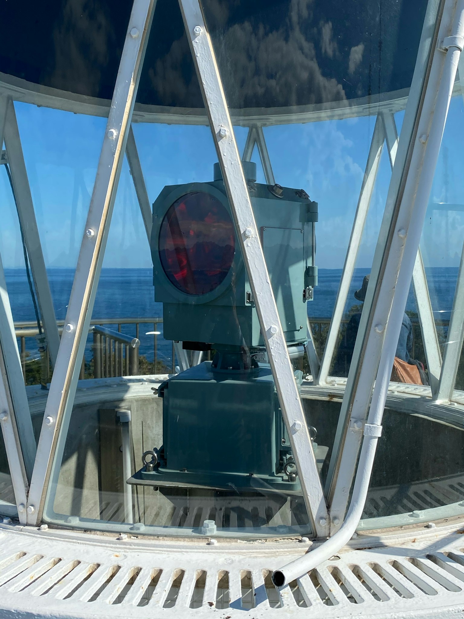 Innensicht eines Leuchtturms mit rotem Licht vor blauem Ozeanhorizont