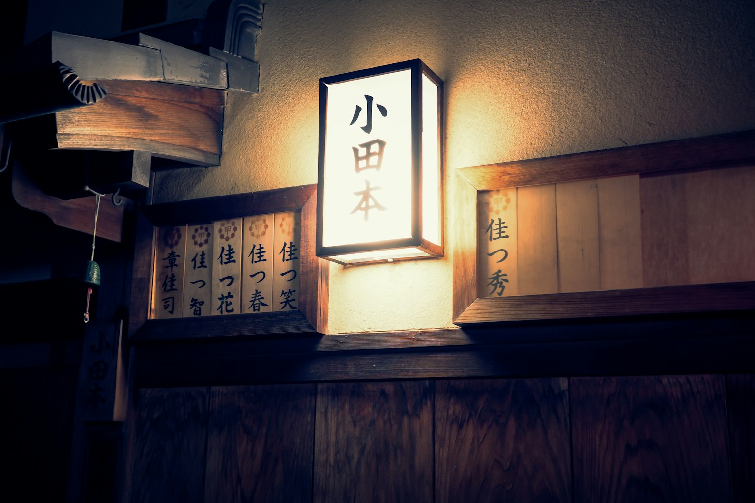 Japanese-style lamp and sign on wooden wall