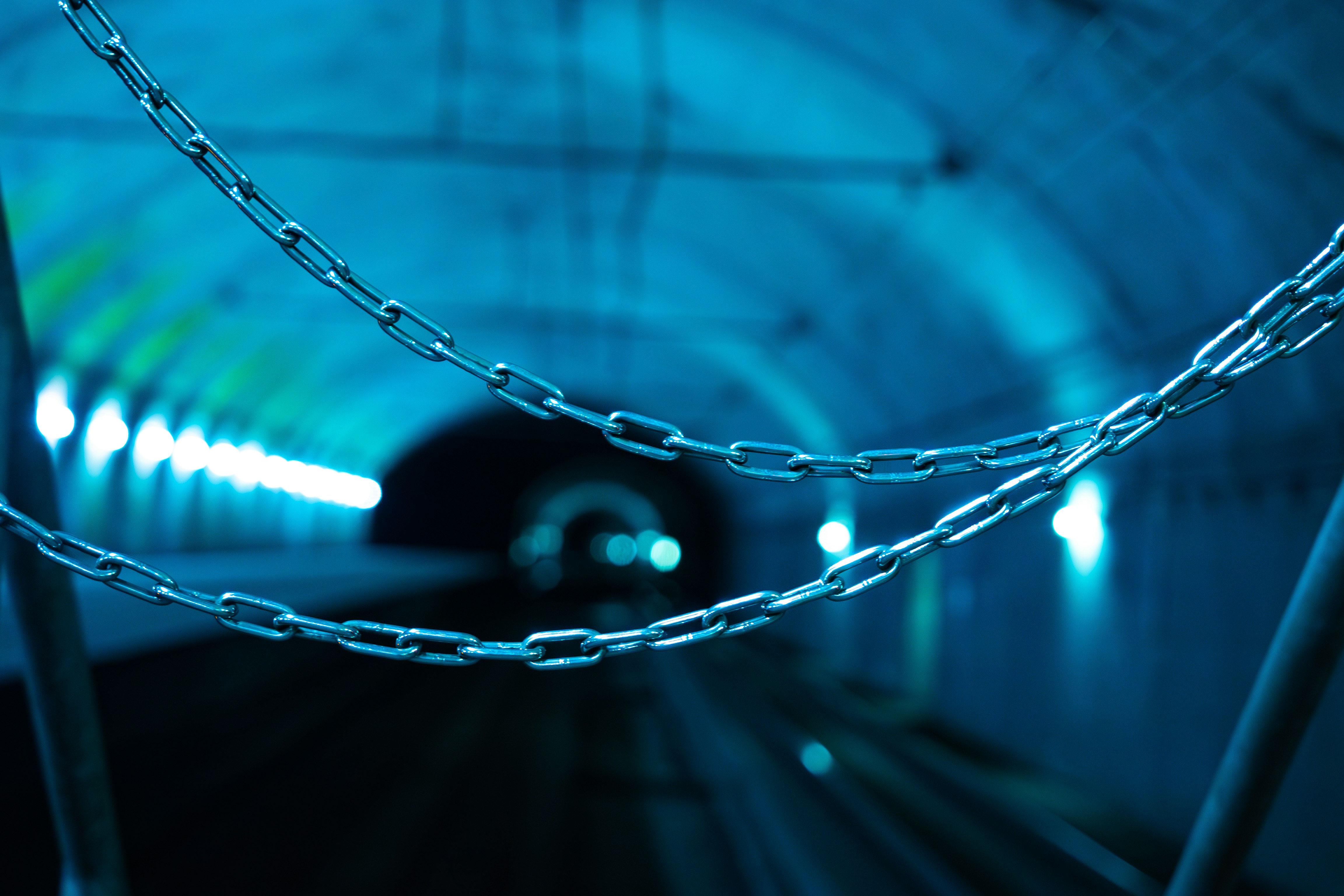 catene metalliche sospese in un tunnel illuminato di blu