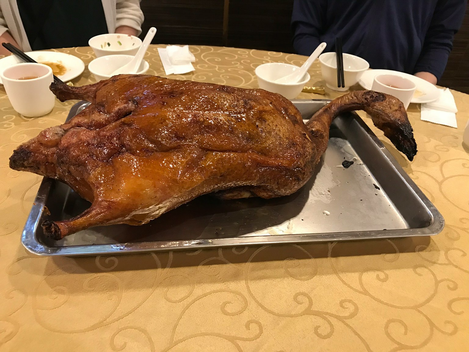Seekor bebek panggang utuh disajikan di atas nampan di meja makan