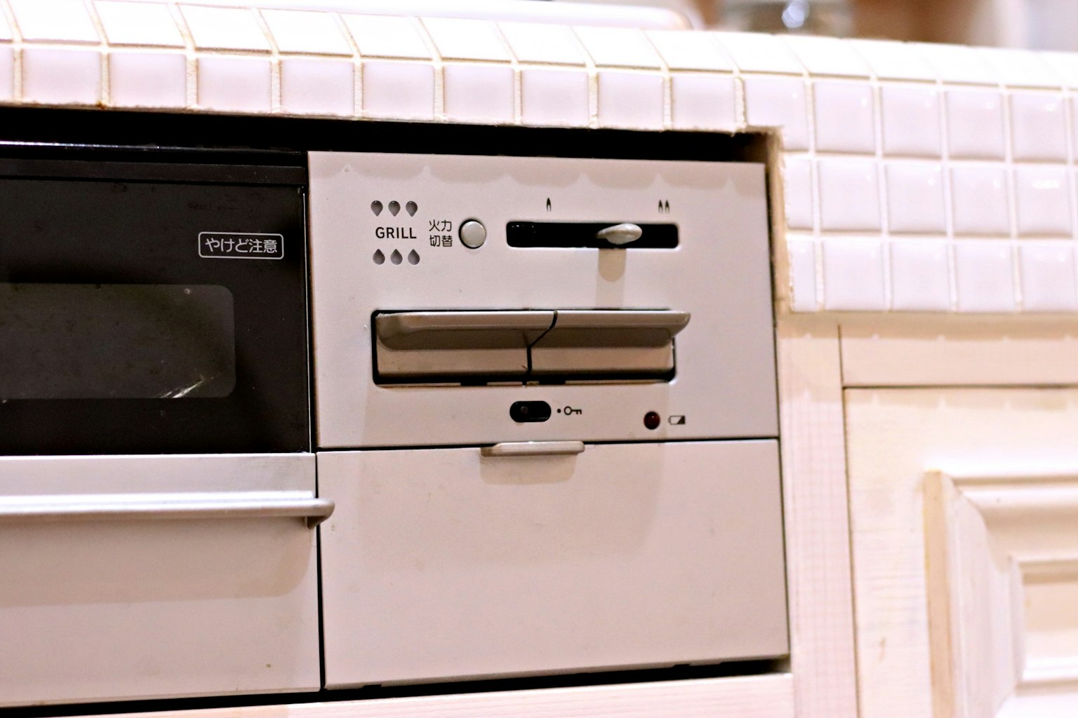 Panel de control de un electrodoméstico blanco de cocina con puerta deslizante