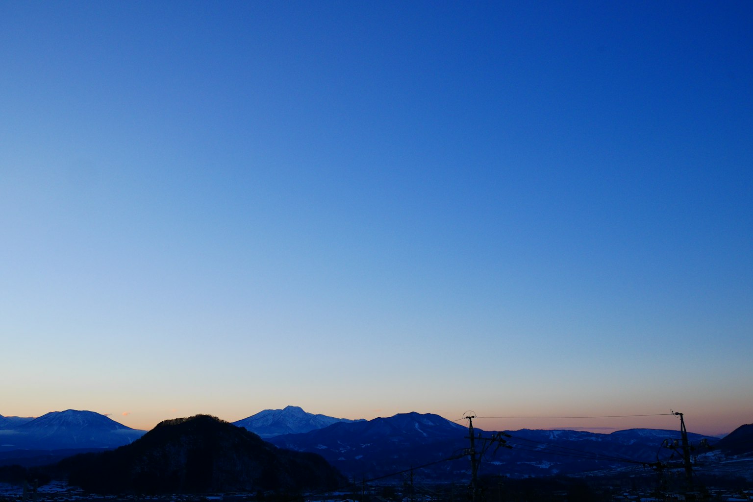 宁静的风景，远处的山脉和蓝色的天空在黄昏时分