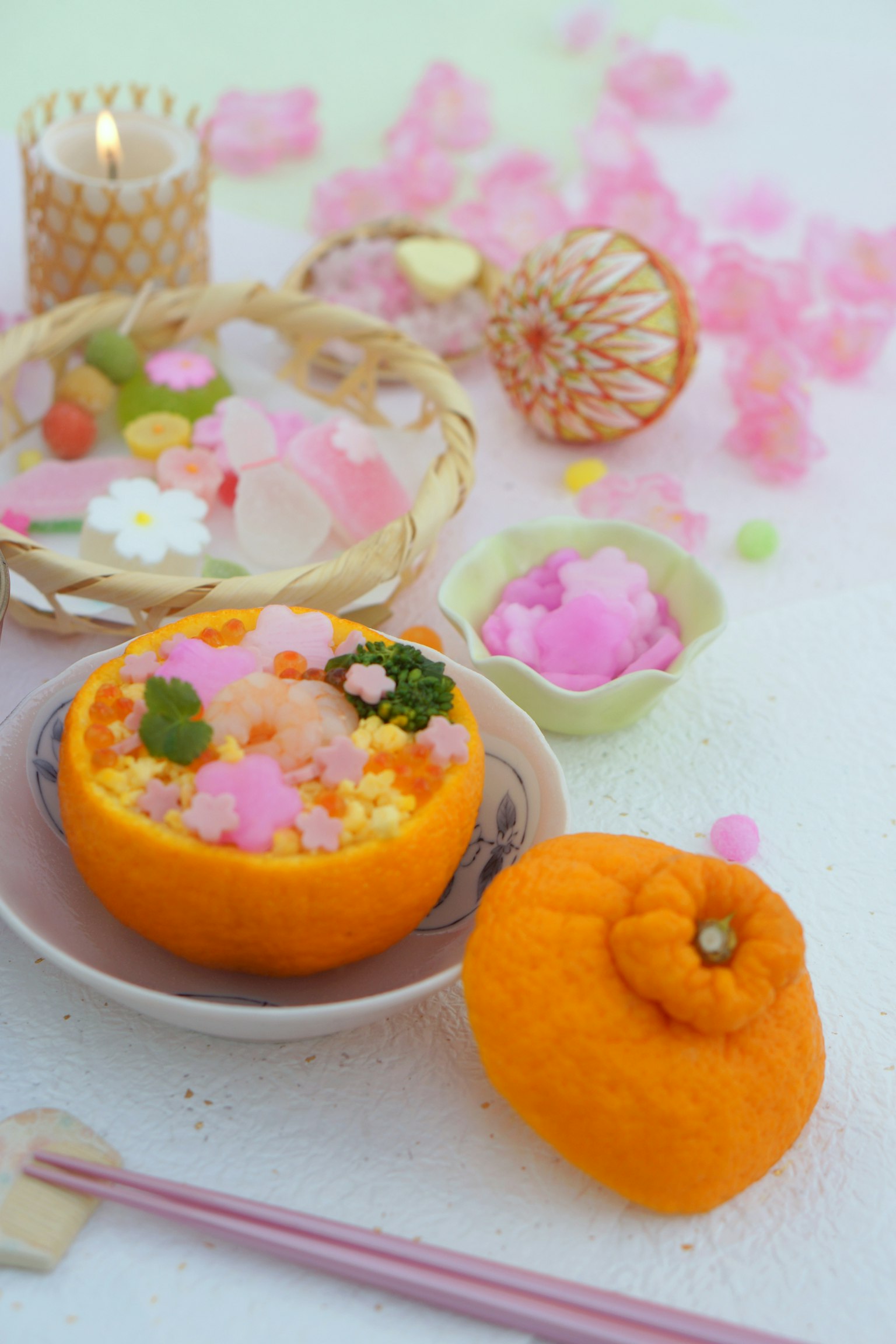 色彩丰富的菜肴盛在橙色碗中，装饰有樱花花瓣