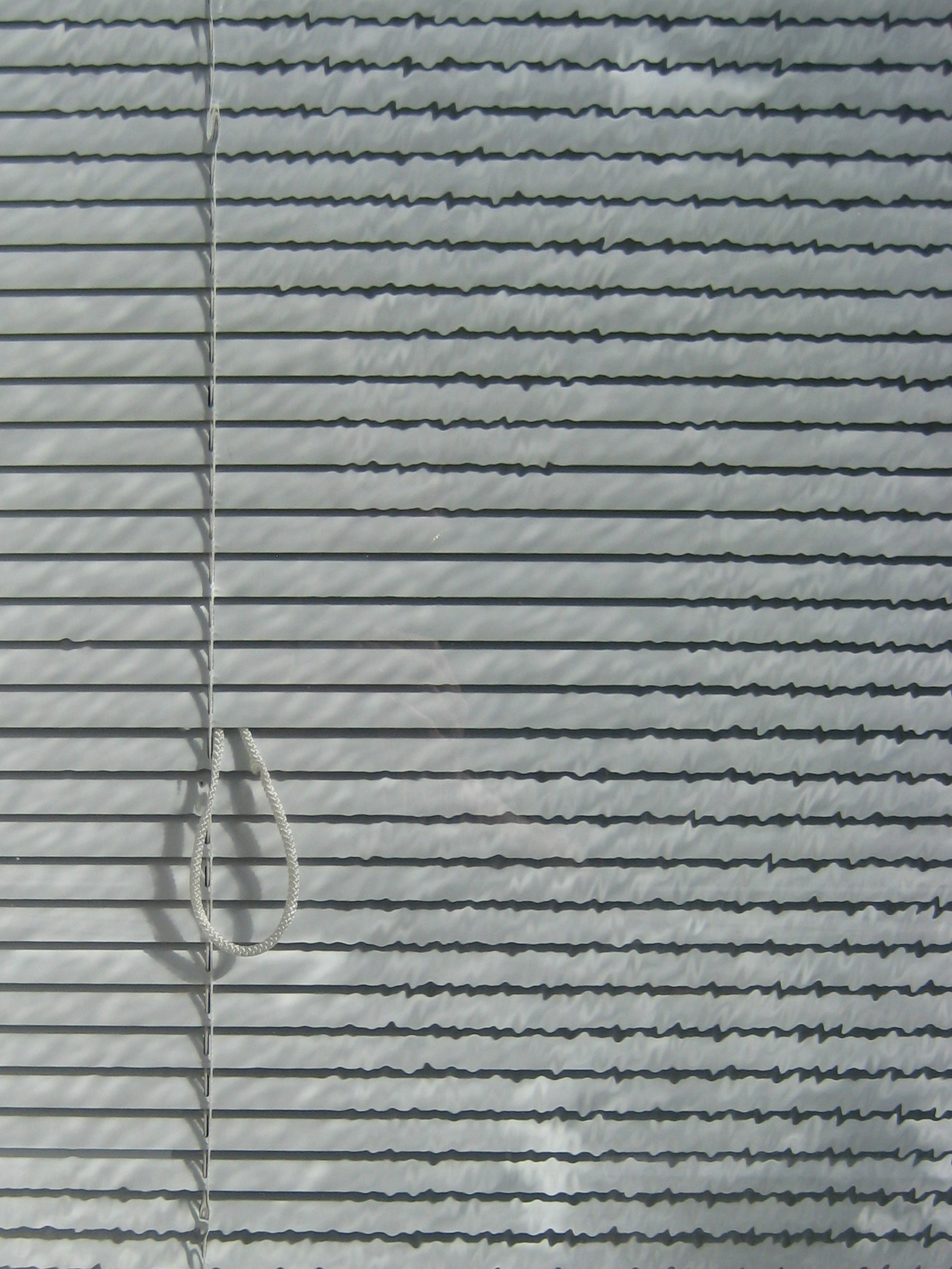 Lumière et ombres à travers un store rayé