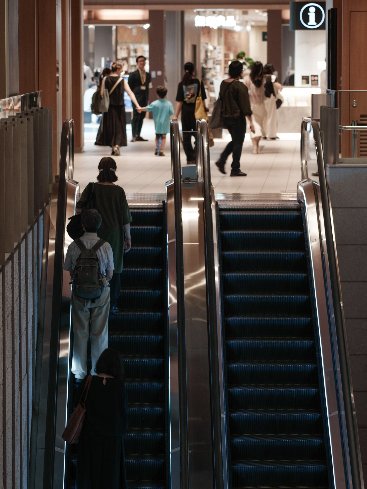 Cảnh nội thất của trung tâm thương mại với mọi người trên thang cuốn và ở phía sau