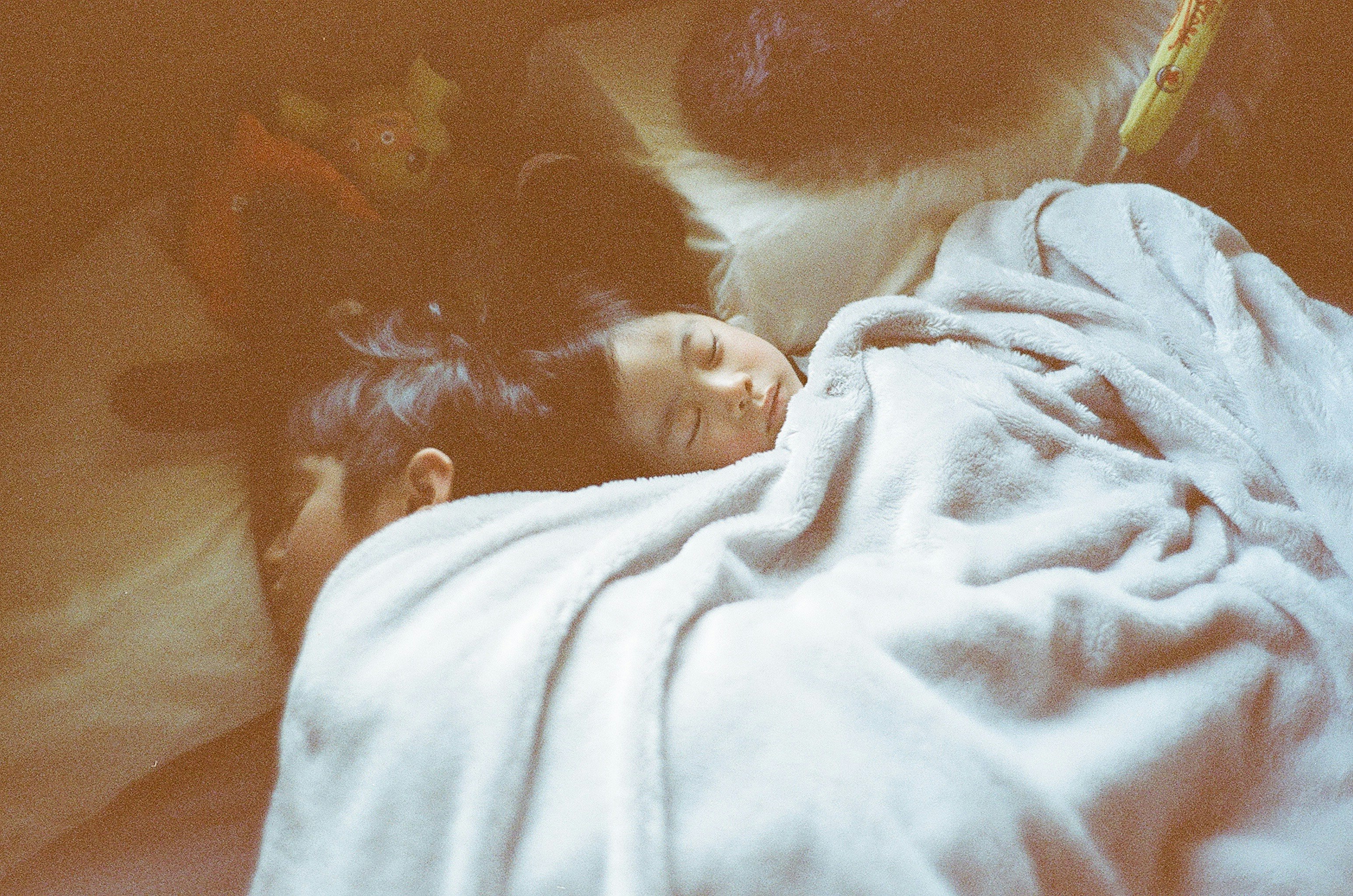 二人の子供が毛布に包まれて眠っているシーン