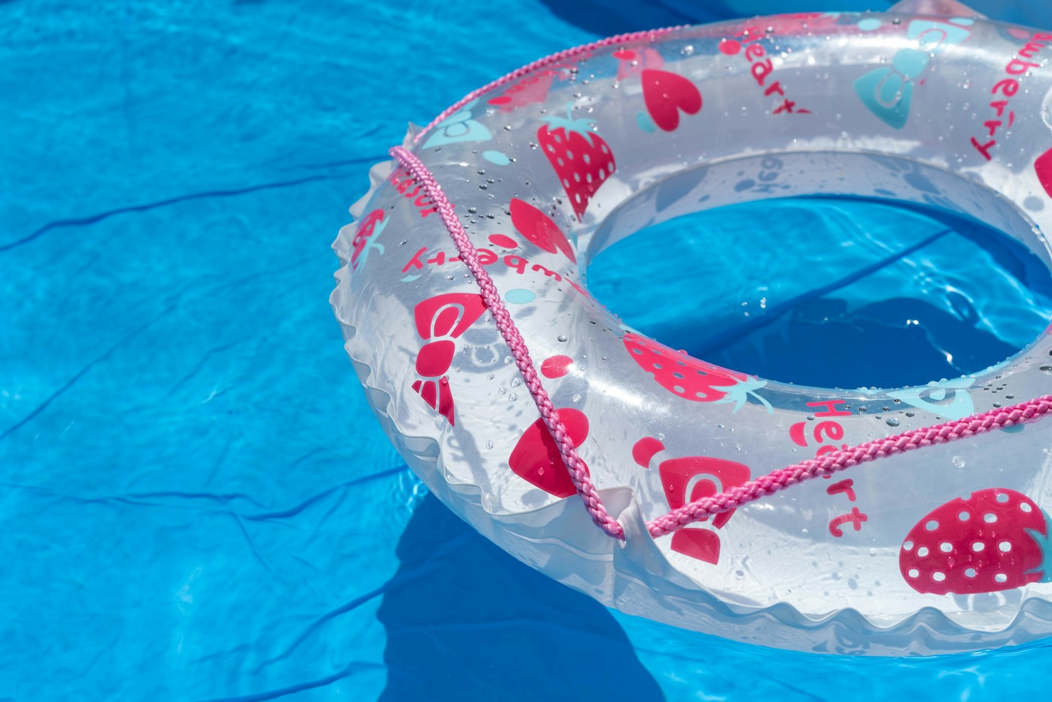Un flotador transparente con diseño de corazones en una piscina