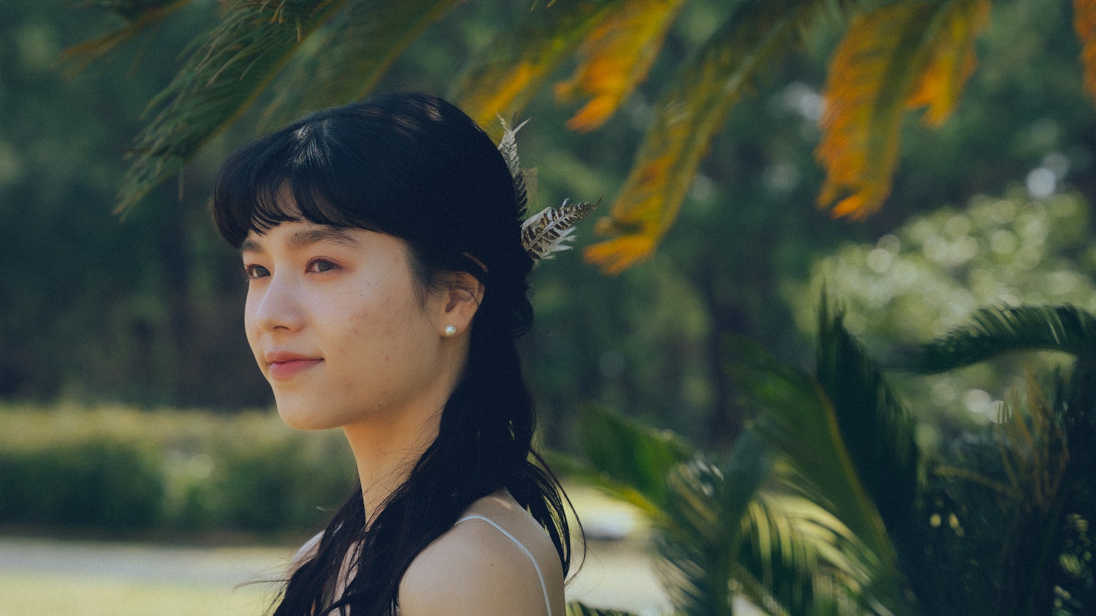 年輕女性在綠色戶外環境中微笑