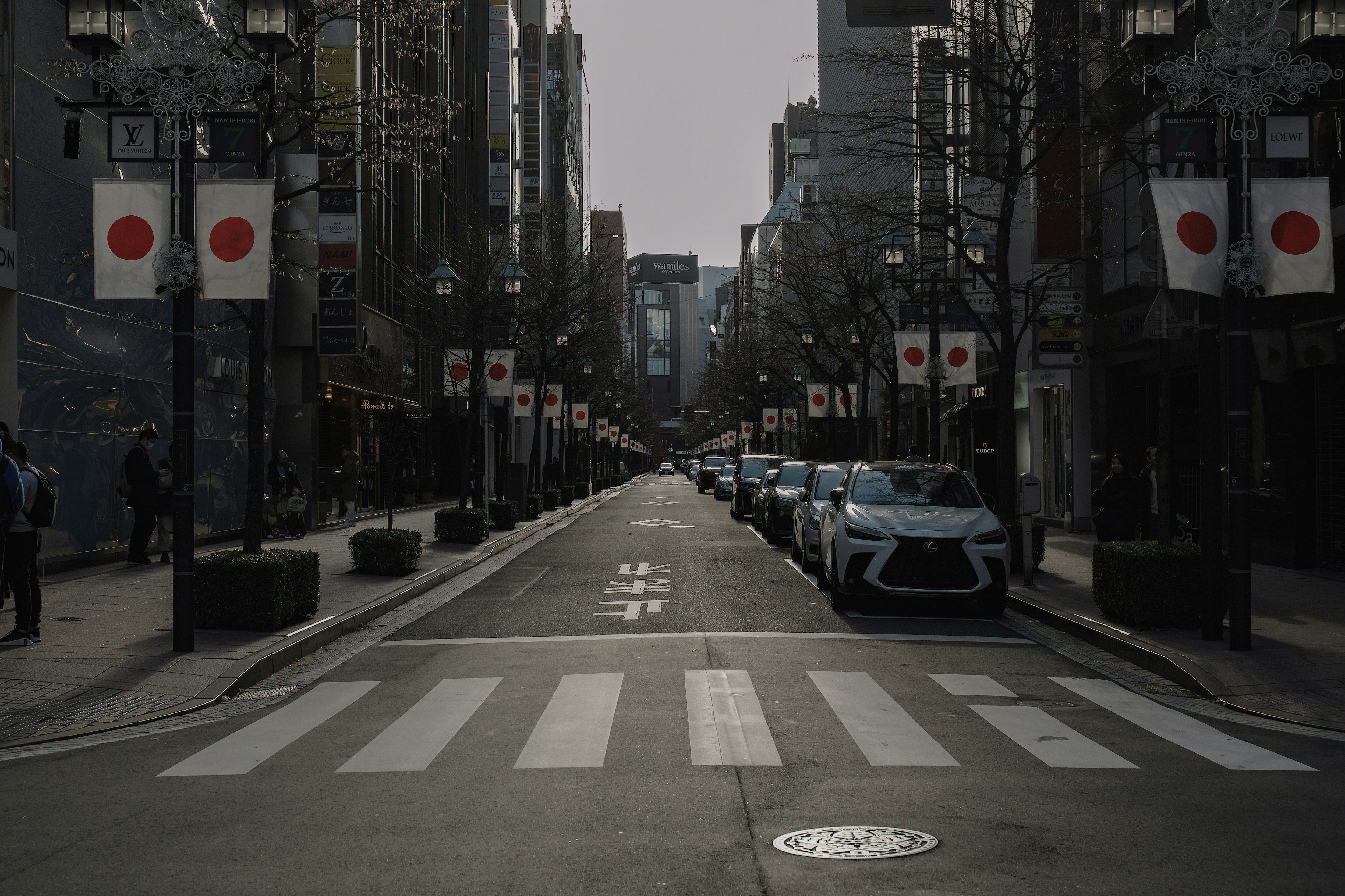 銀座の交詢社通りに掲げられた国旗のある街並み