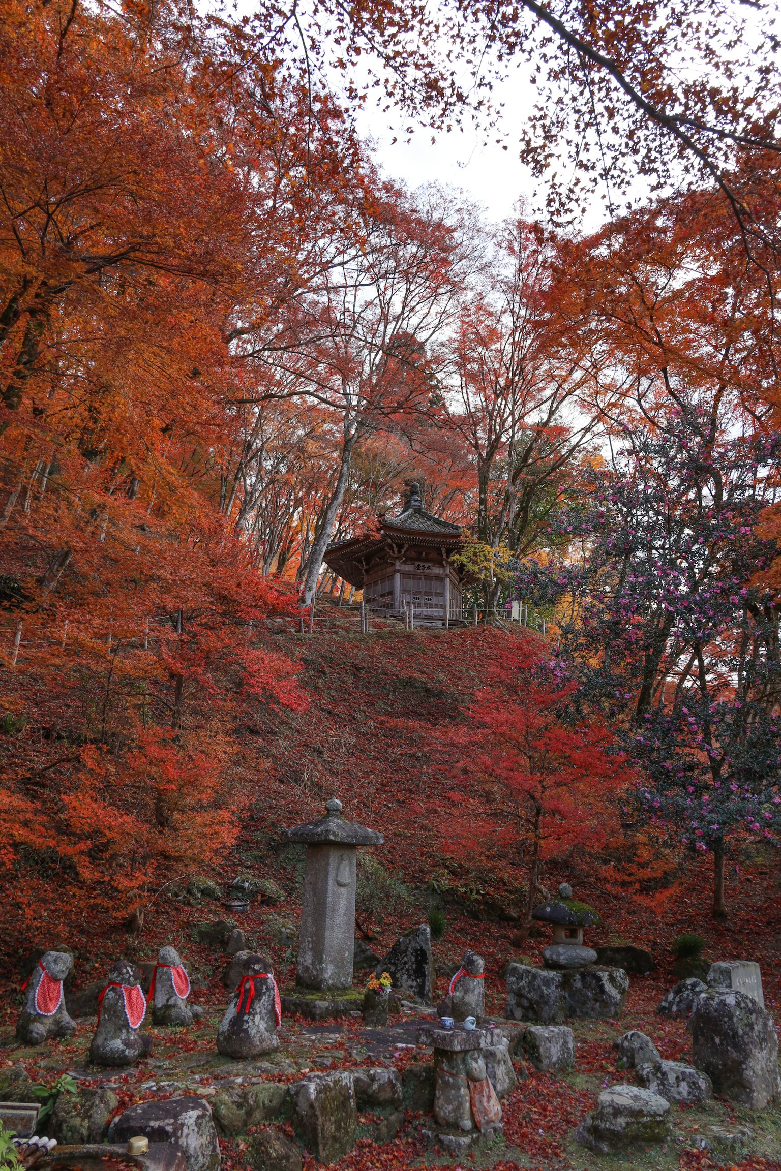 Vista panoramica di un tempio circondato da fogliame autunnale con statue di pietra