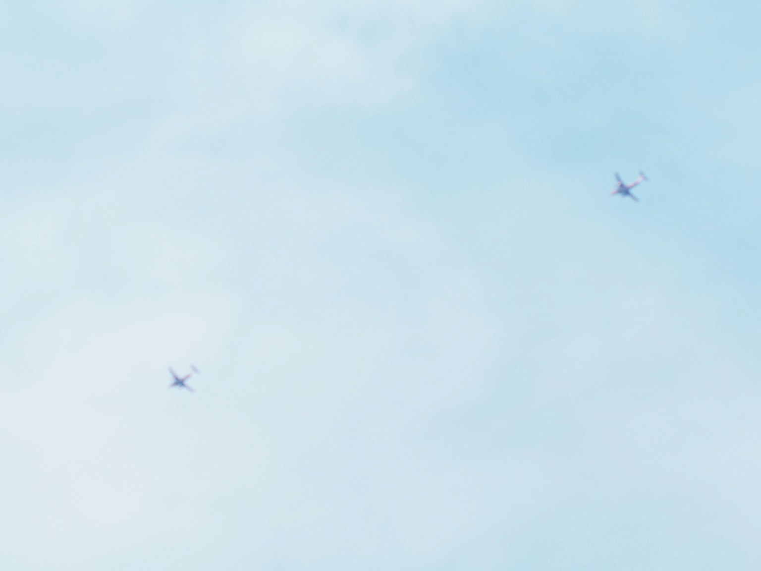 Dua pesawat kecil terbang di langit biru