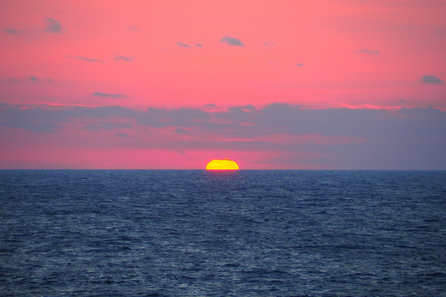 海平线上落下的夕阳和粉色的天空
