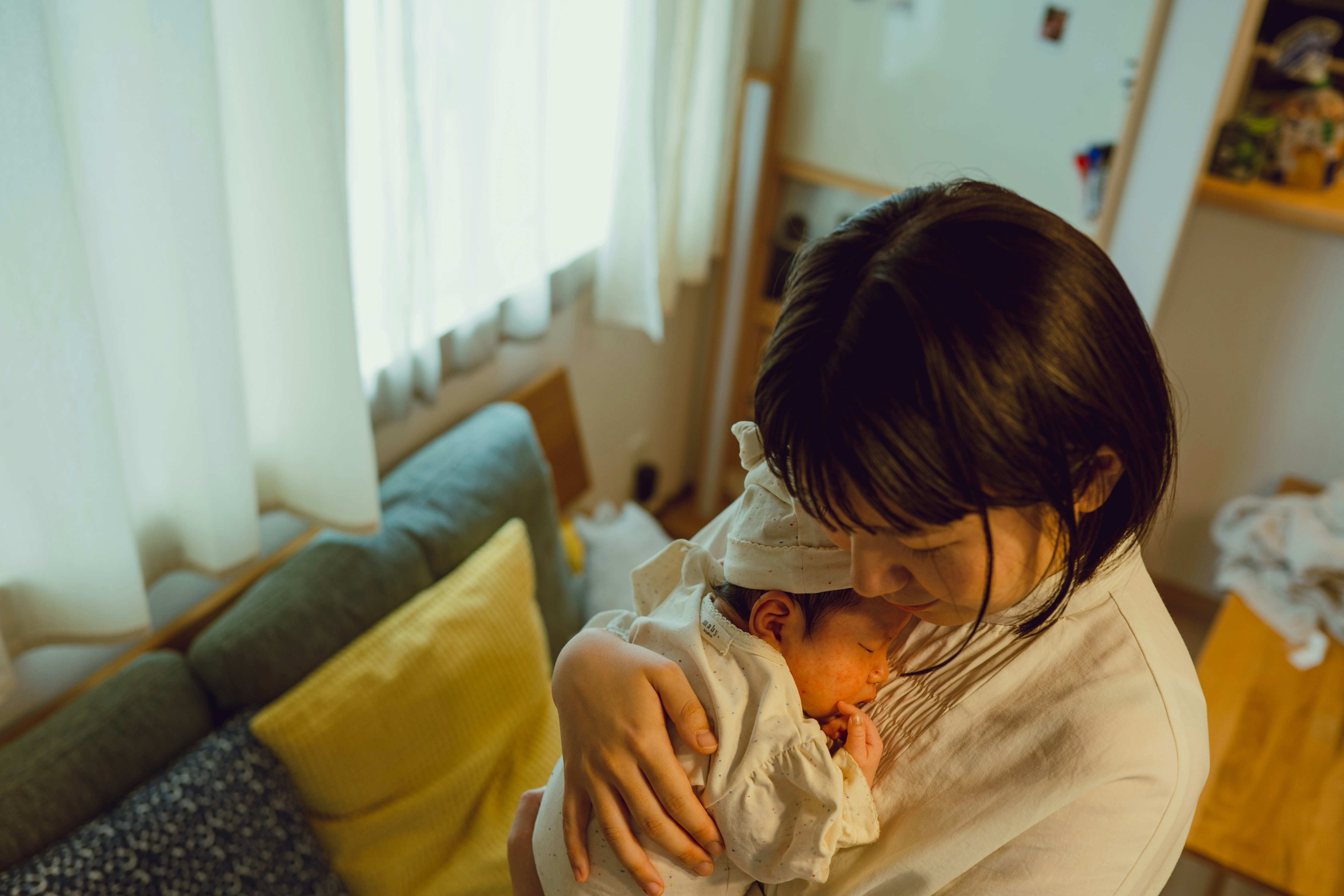 Parent holding a baby while cuddling on a sofa