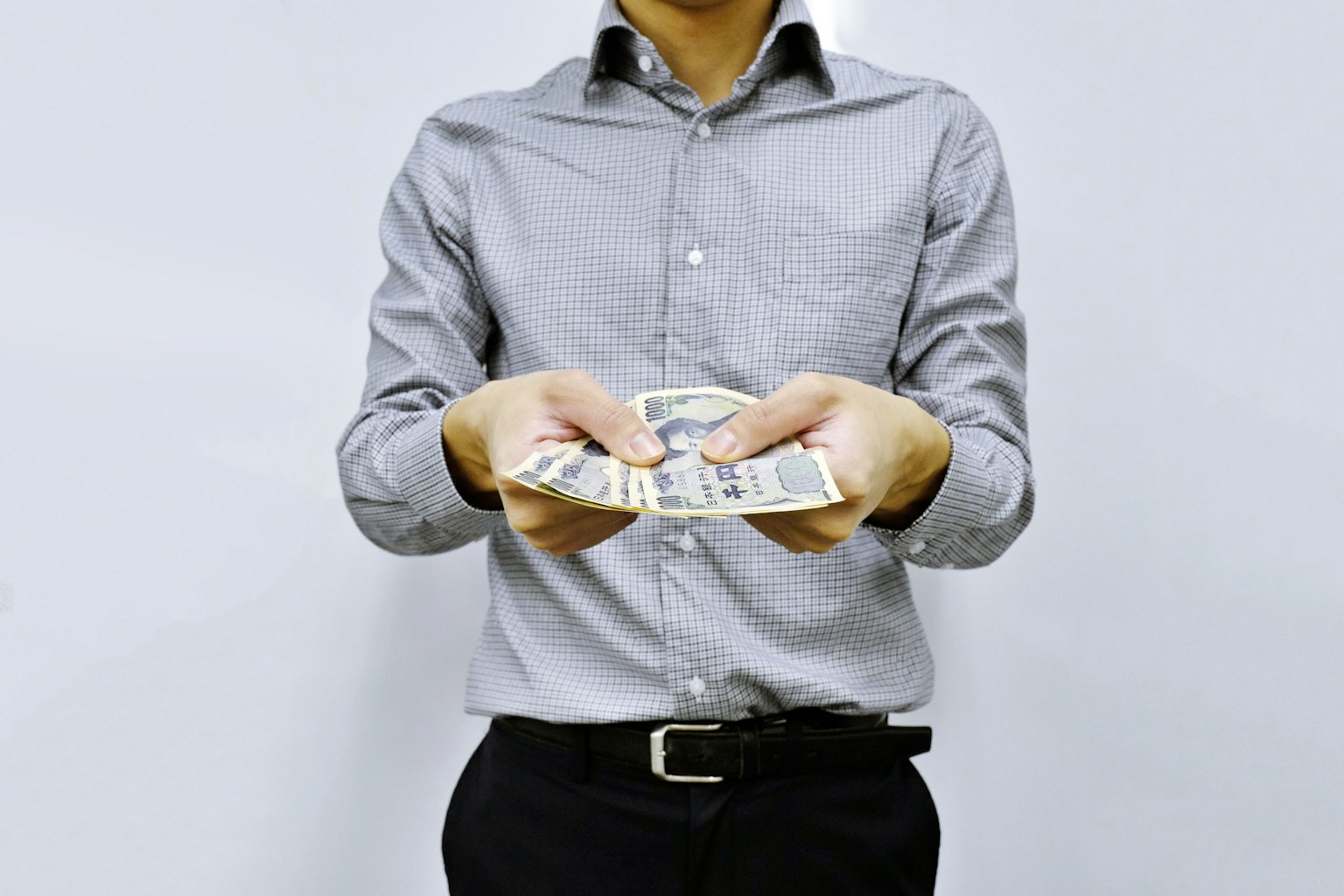 Uomo in camicia che tiene denaro