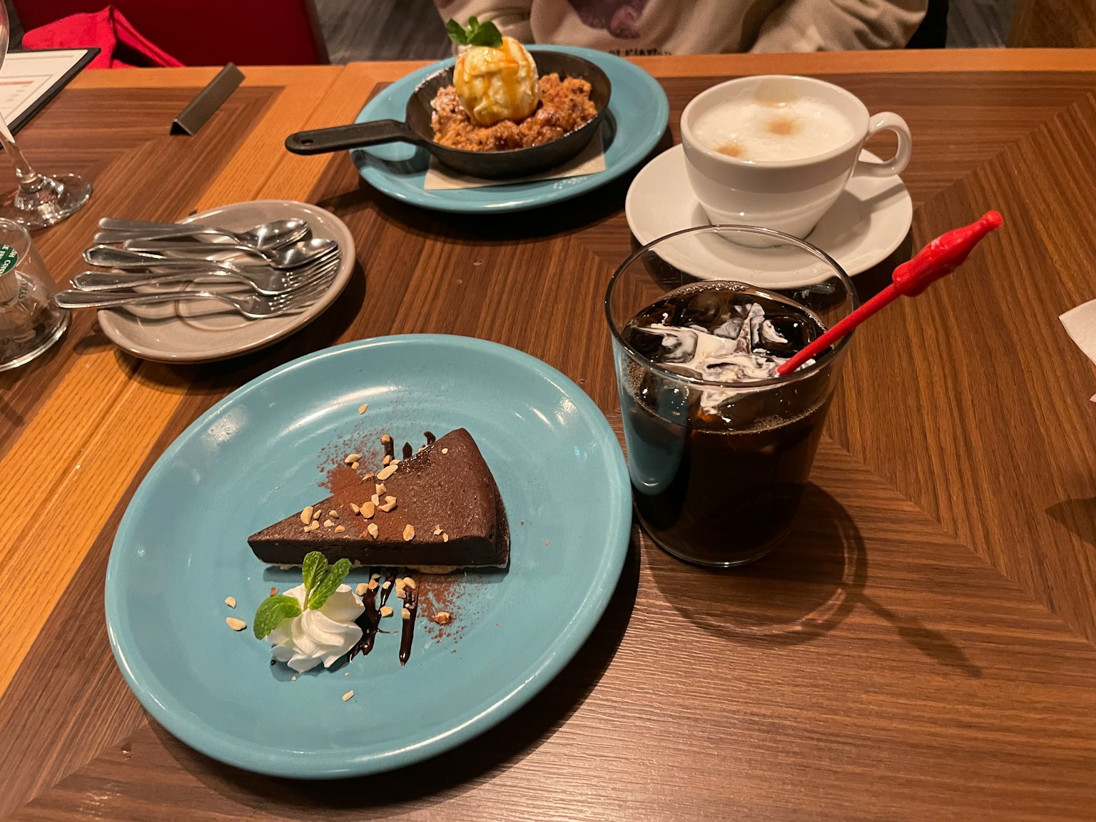 Dessert sur une assiette bleue avec un gâteau au chocolat garni de crème fouettée et d'une tranche de lime sur une table en bois